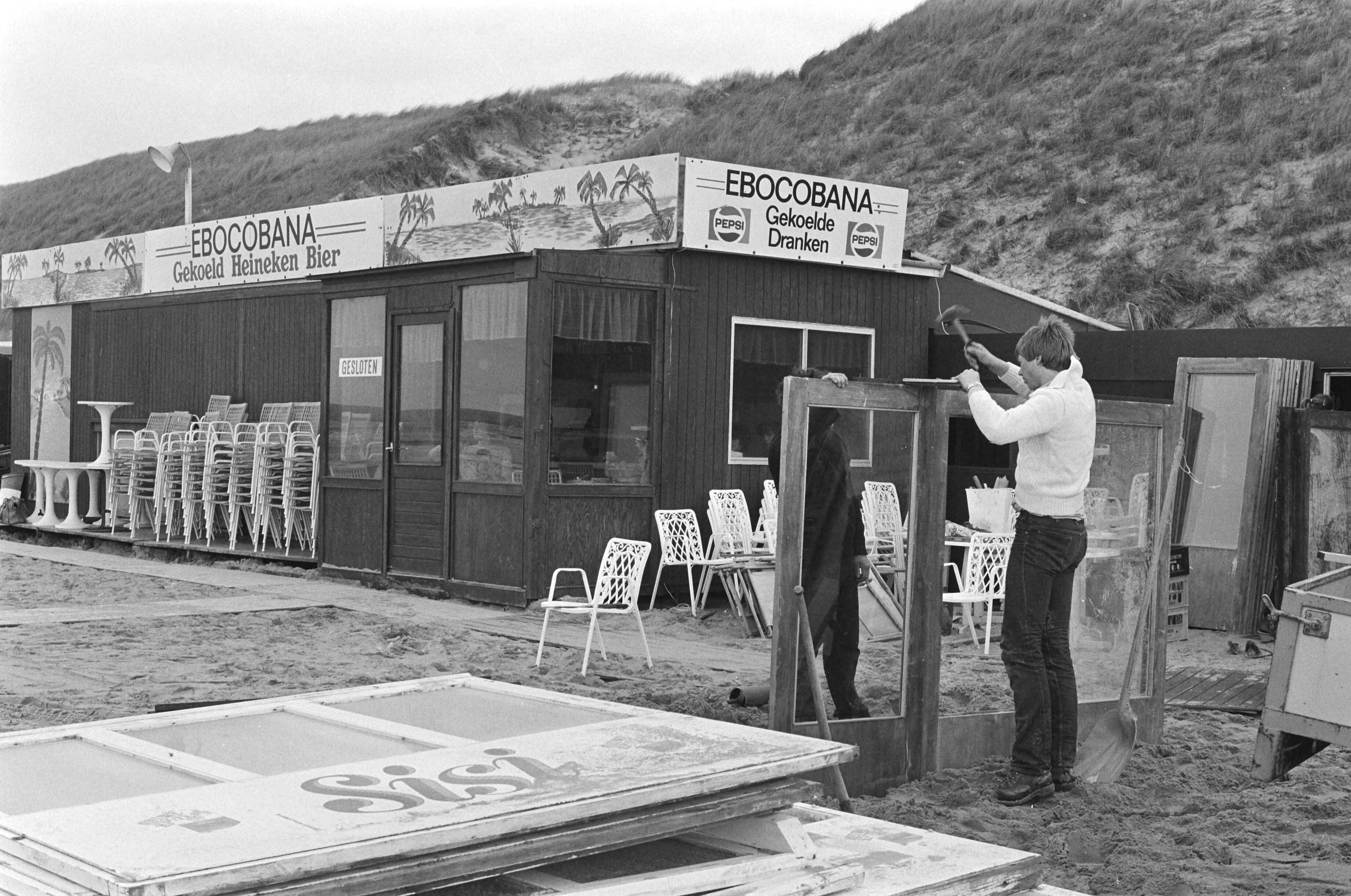 Fotocollectie Anefo — Herstelwerkzaamheden aan door stormschade getroffen strandtenten en paviljoens in Zandvoort; herstelwerkzaamheden aan windafzetting — Foto: Dijk, Hans van / Anefo. Licentie: Set B: Rechtenvrij / Publiek Domein. Bron: Nationaal Archief. http://hdl.handle.net/10648/acdeaeb8-d0b4-102d-bcf8-003048976d84