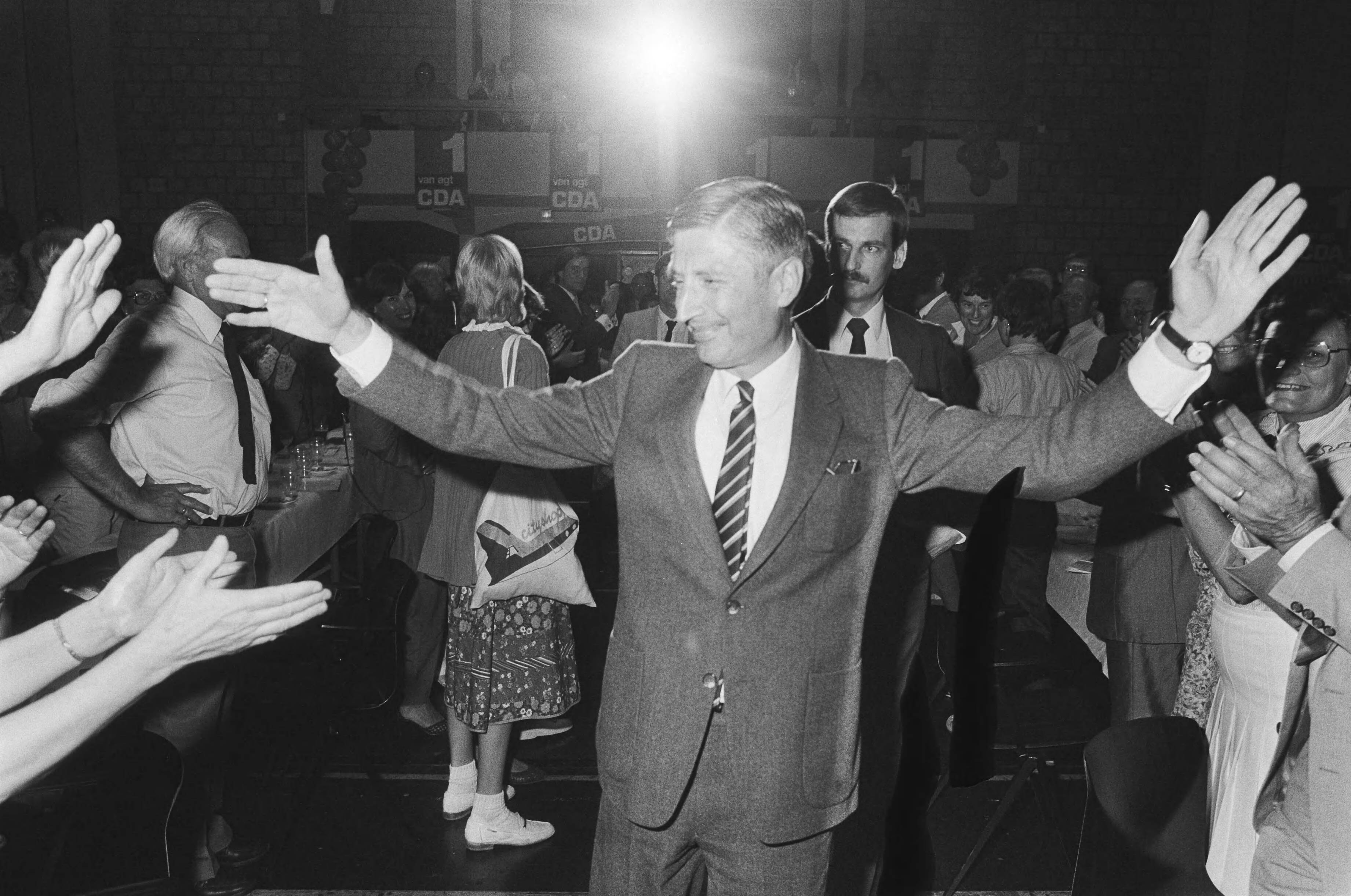 Fotocollectie Anefo — Tevens opdracht CDA, verkiezingsbijeenkomst CDA in Kerkrade zwaaiende Van Agt — Foto: Bogaerts, Rob / Anefo. Licentie: Set B: Rechtenvrij / Publiek Domein. Bron: Nationaal Archief. http://hdl.handle.net/10648/ad1dc5ee-d0b4-102d-bcf8-003048976d84