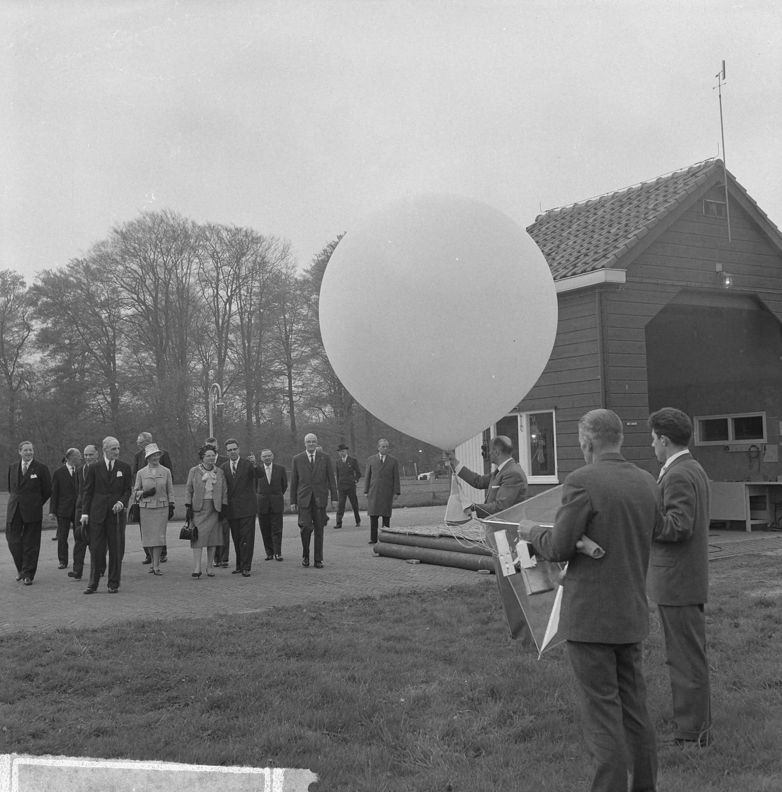 Fotocollectie Anefo — Bezoek van koningin Juliana aan het KNMI in De Bilt. Een weerballon wordt opgelaten — Foto: Nijs, Jac. de / Anefo. Licentie: Set B: Rechtenvrij / Publiek Domein. Bron: Nationaal Archief. http://hdl.handle.net/10648/aa35f6c6-d0b4-102d-bcf8-003048976d84