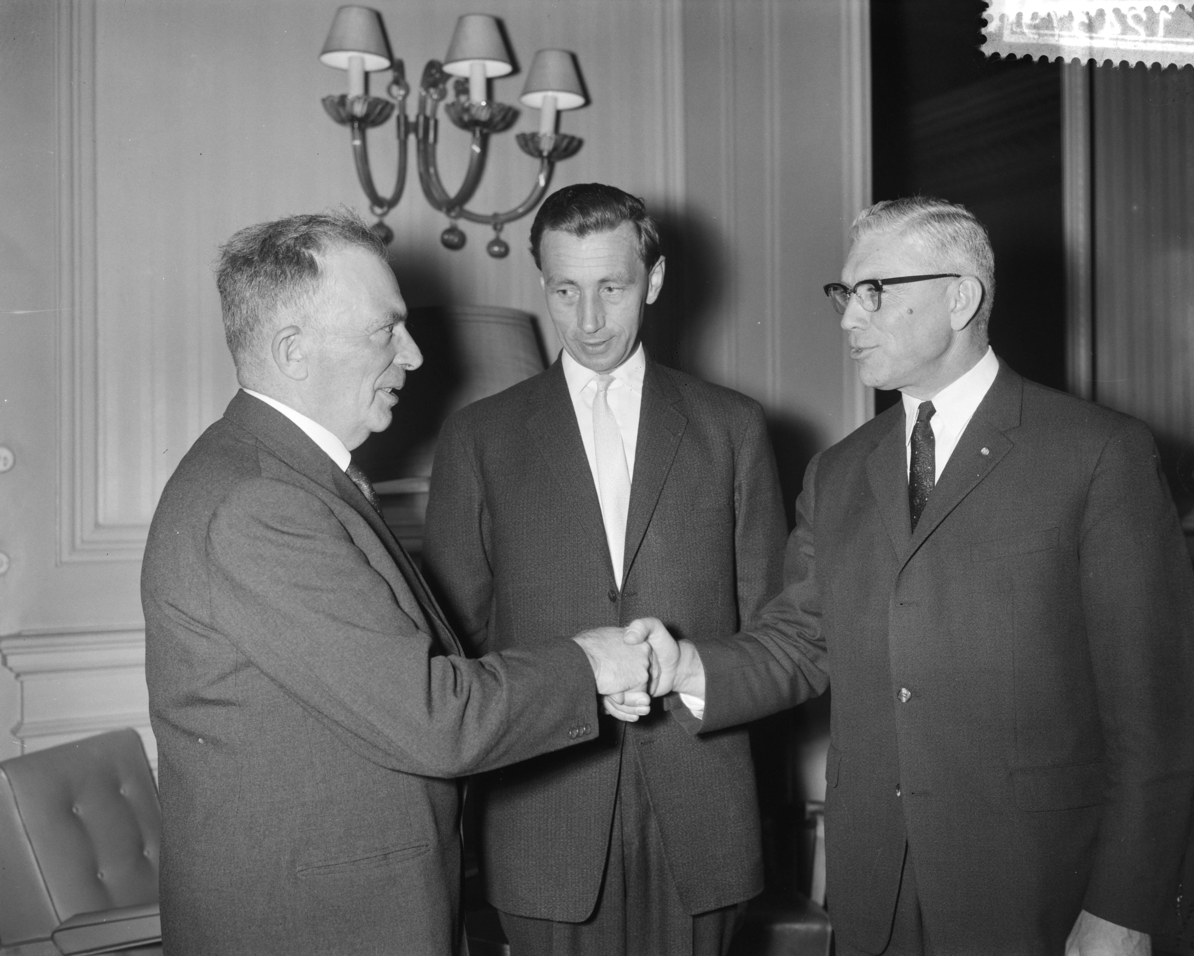 Fotocollectie Anefo — Afscheid van de directeur-generaal van de Landbouw ir. A.W. van der Plassche (links). Hij schudt de hand van ir. C.S. Knottnerus, voorzitter van het Koninklijk Nederlands Landbouwcomité. In het midden zijn opvolger ir. J.W. Wellen — Foto: Bilsen, Joop van / Anefo. Licentie: Set B: Rechtenvrij / Publiek Domein. Bron: Nationaal Archief. http://hdl.handle.net/10648/a9d3cd70-d0b4-102d-bcf8-003048976d84