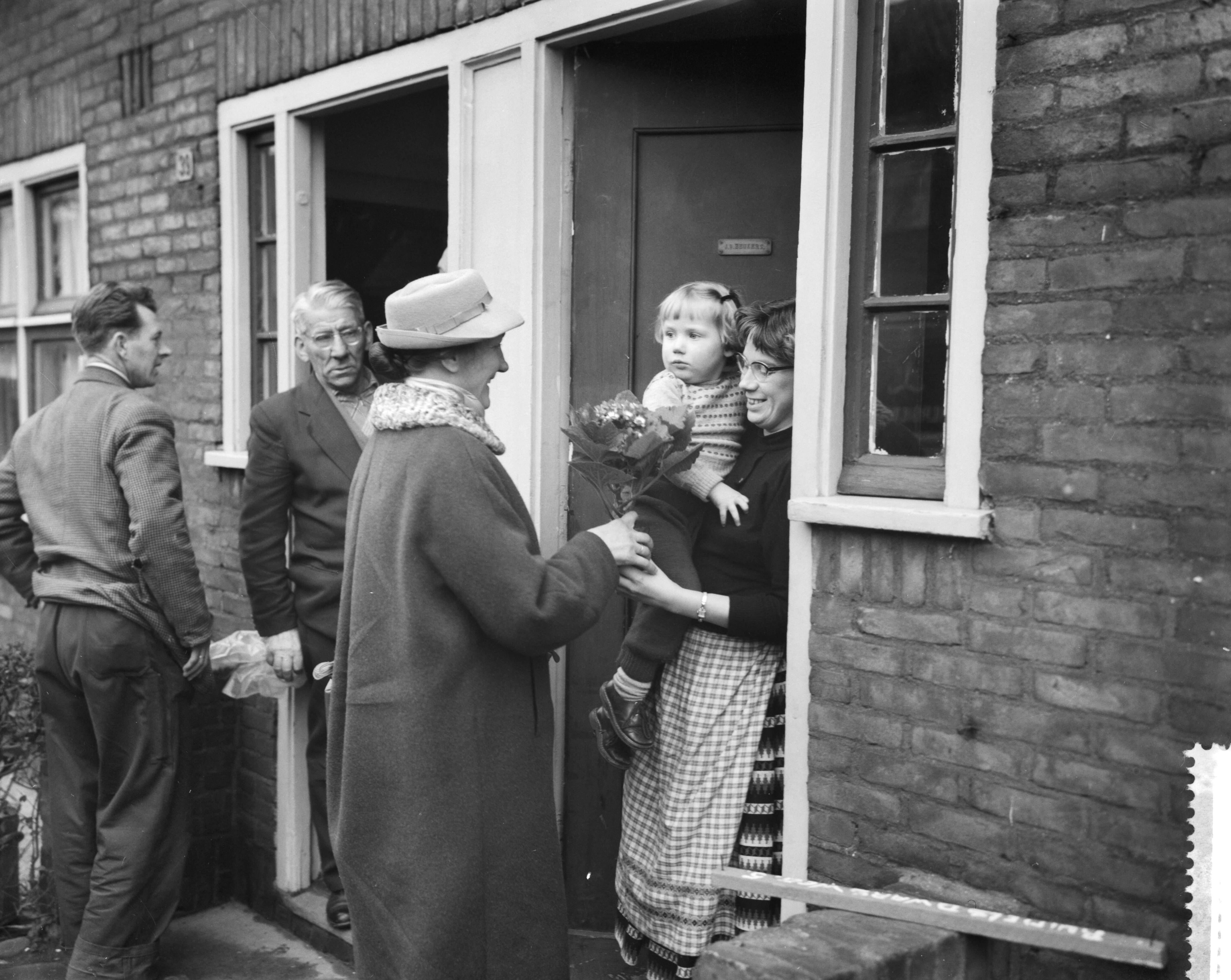 Fotocollectie Anefo — Vrouwen van Schouwen-Duiveland schenken bloemen aan Tuindorp Oostzaan. Vrouwen delen bloemen uit — Foto: Rossem, Wim van / Anefo. Licentie: Set B: Rechtenvrij / Publiek Domein. Bron: Nationaal Archief. http://hdl.handle.net/10648/a9a7ef20-d0b4-102d-bcf8-003048976d84