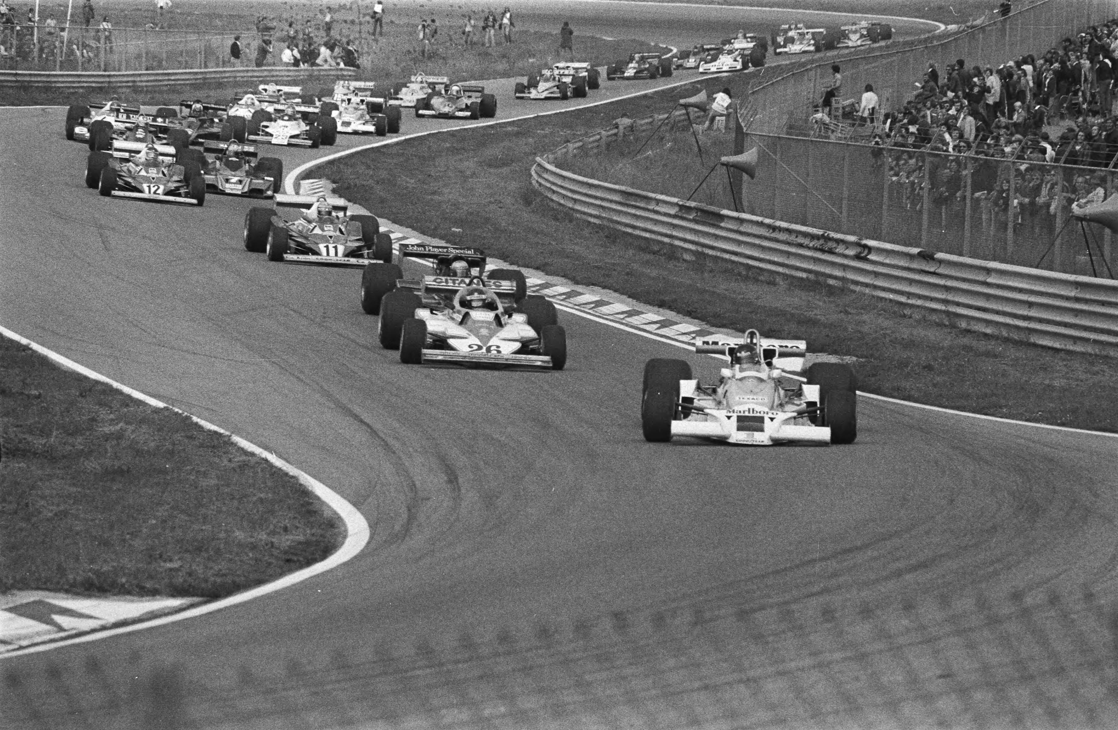 Fotocollectie Anefo — Grand Prix Zandvoort; kort na de start met James Hunt op kop — Foto: Suyk, Koen / Anefo. Licentie: Set B: Rechtenvrij / Publiek Domein. Bron: Nationaal Archief. http://hdl.handle.net/10648/aca1b4ae-d0b4-102d-bcf8-003048976d84