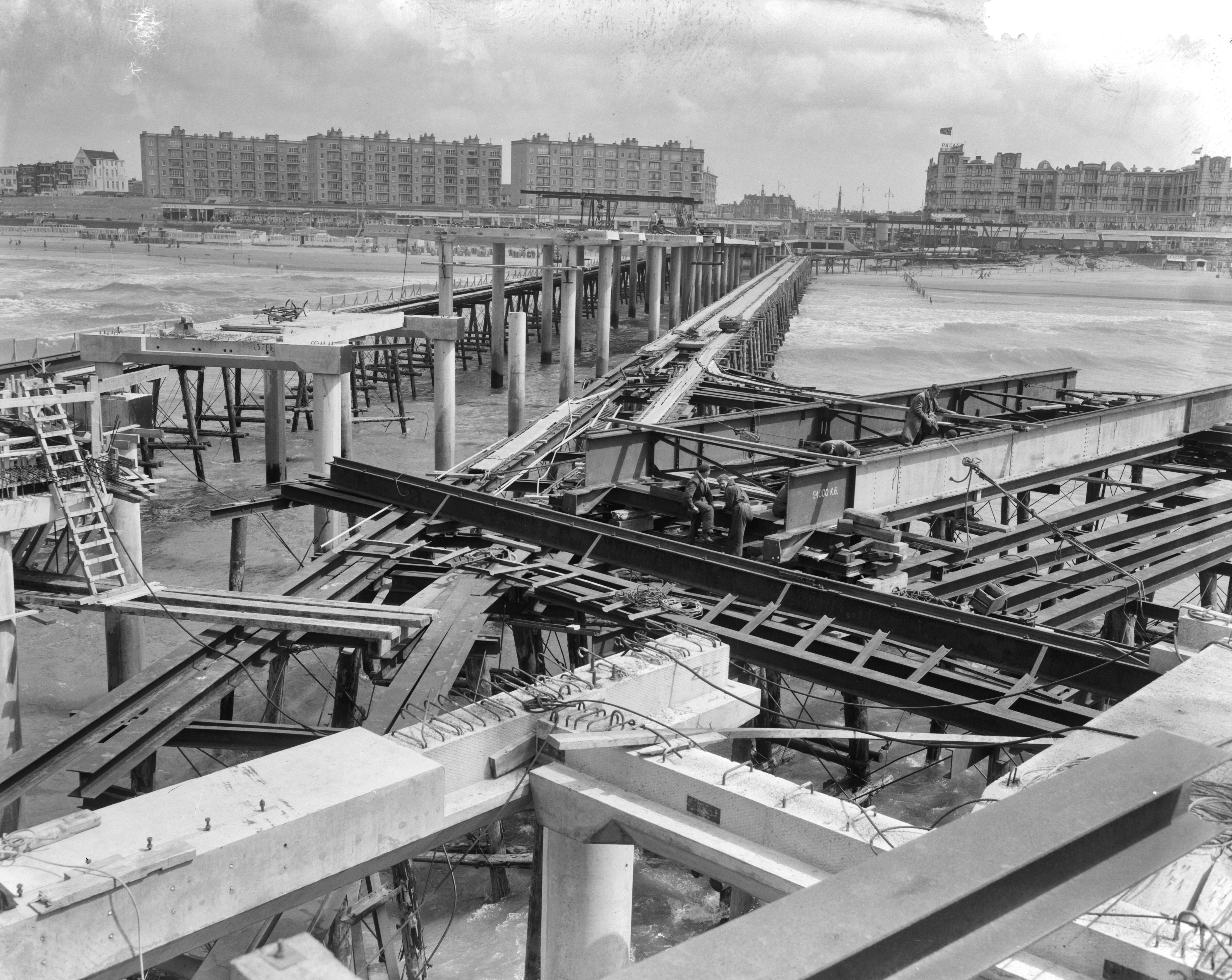 Fotocollectie Anefo — Bouw pier Scheveningen — Foto: Behrens, Herbert F. / Anefo. Licentie: Set B: Rechtenvrij / Publiek Domein. Bron: Nationaal Archief. http://hdl.handle.net/10648/a9b4bc32-d0b4-102d-bcf8-003048976d84