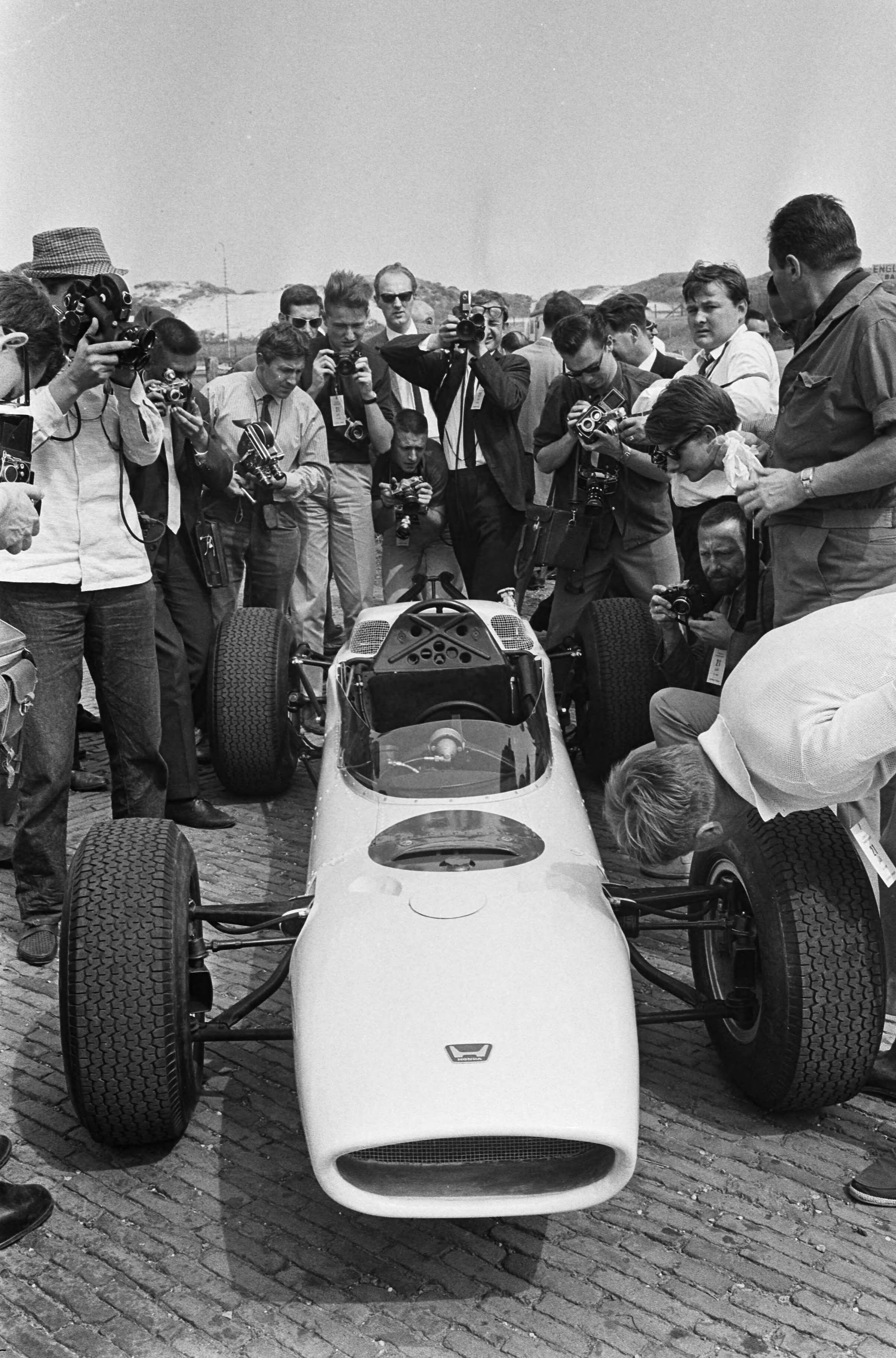 Fotocollectie Anefo — Autoprimeur op het Zandvoortse circuit. Perspresentatie van testritten van de Japanse Honda 12 cylindermoter Formule 1 raceauto, gereden door Ron Bucknum — Foto: Pot, Harry / Anefo (1). Licentie: Set B: Rechtenvrij / Publiek Domein. Bron: Nationaal Archief. http://hdl.handle.net/10648/aa719636-d0b4-102d-bcf8-003048976d84