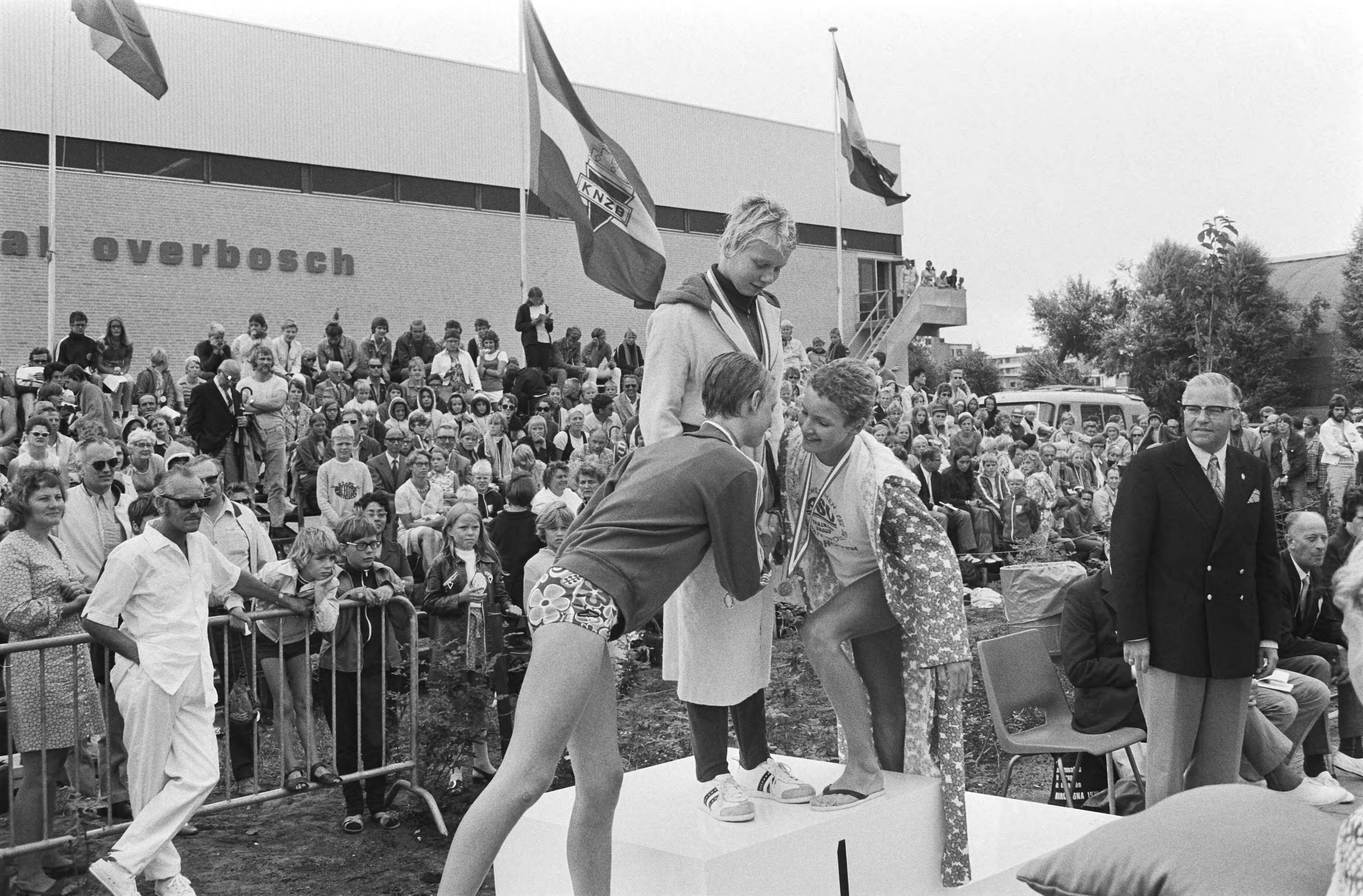 Fotocollectie Anefo — Nationale kampioenschappen zwemmen te Den Haag in zwembad Overbosch, huldiging Louise van Vliegen (midden) — Foto: Peters, Hans / Anefo. Licentie: Set B: Rechtenvrij / Publiek Domein. Bron: Nationaal Archief. http://hdl.handle.net/10648/abc7d69e-d0b4-102d-bcf8-003048976d84
