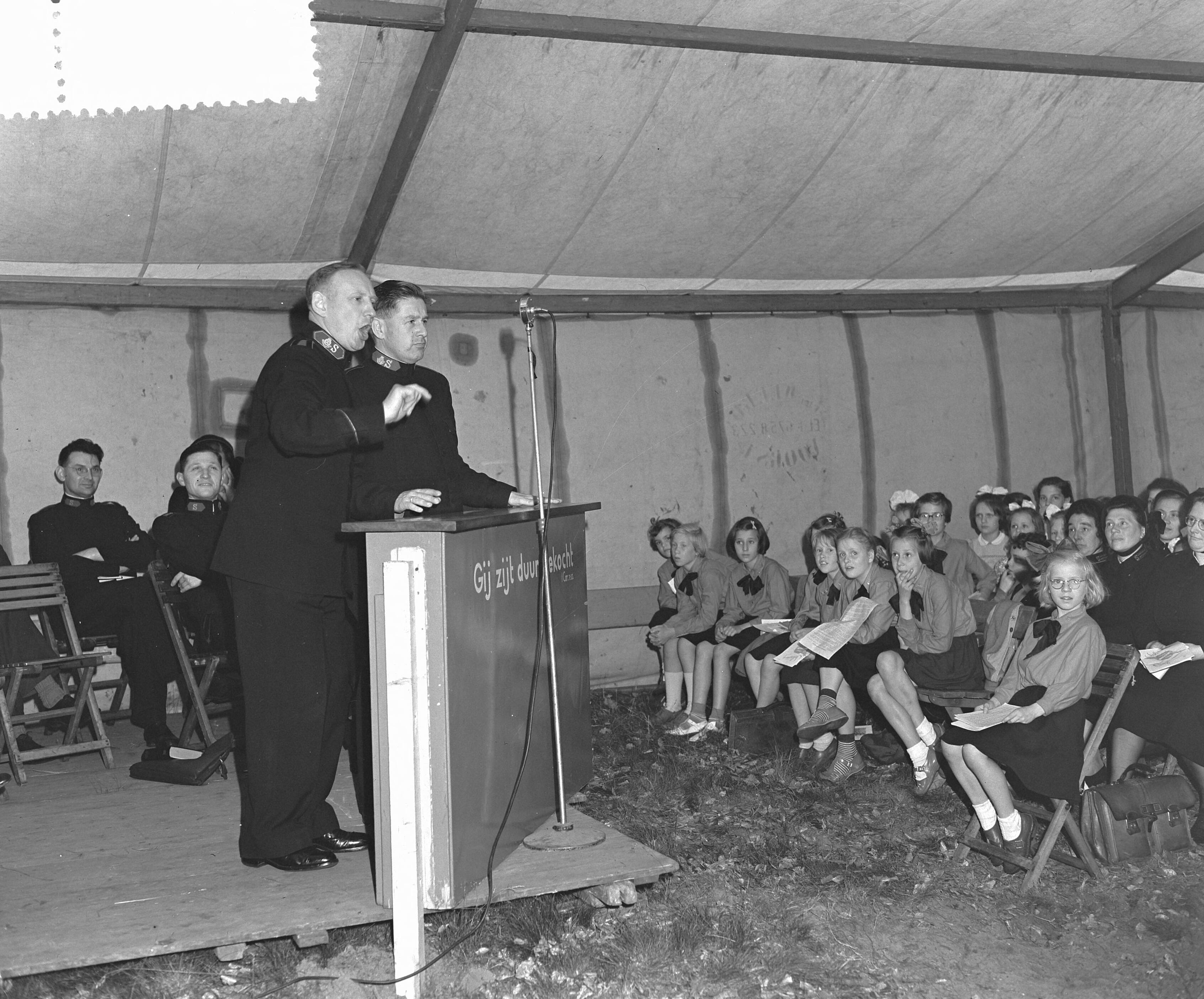 Fotocollectie Anefo — Nationale Velddag van het Leger des Heils te Baarn (jeugddag). Toespraak van kolonel Westergaard uit Londen — Foto: Rossem, Wim van / Anefo. Licentie: Set B: Rechtenvrij / Publiek Domein. Bron: Nationaal Archief. http://hdl.handle.net/10648/a9242ba4-d0b4-102d-bcf8-003048976d84