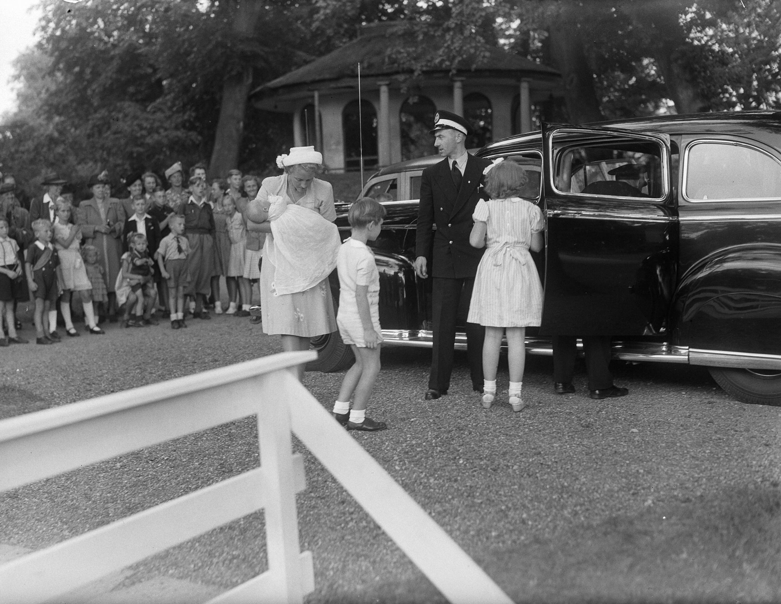 Fotocollectie Anefo — Prinselijk gezin in Leeuwarden. Kinderverzorgster mevr. Pennink met prinses Marijke (Christina) bij een hofauto. In het midden de zoon van Commissaris van de Koningin Linthorst Homan. Rechts prinses Beatrix — Foto: Noske, J.D. / Anefo. Licentie: Set B: Rechtenvrij / Publiek Domein. Bron: Nationaal Archief. http://hdl.handle.net/10648/a8ab18cc-d0b4-102d-bcf8-003048976d84