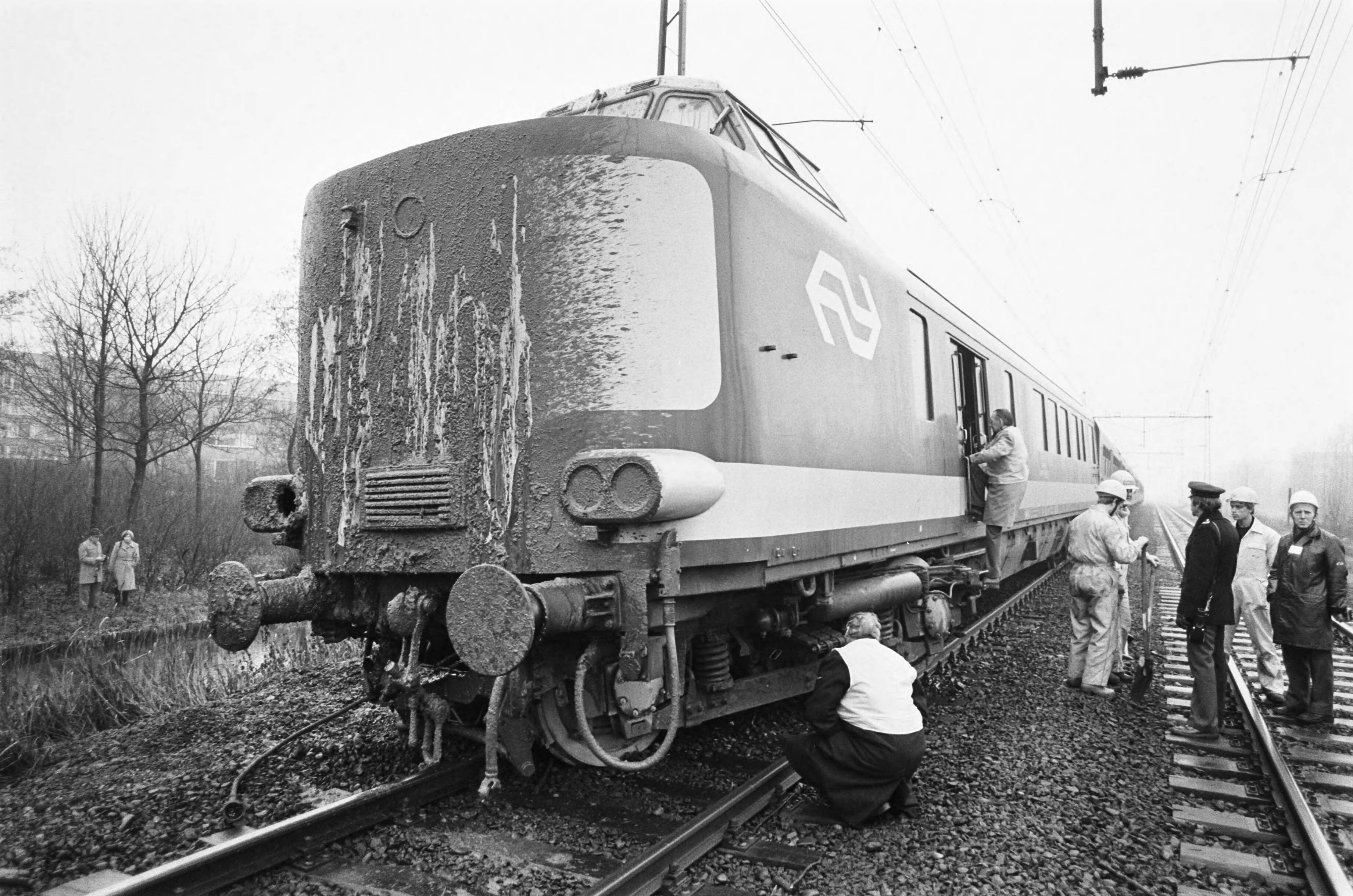 Fotocollectie Anefo — In Rijswijk kwam een trein in botsing met een losgeraakte mestwagen op een bewaakte overgang, de uit de rails gelop trein die nog onder de mest zit — Foto: Antonisse, Marcel / Anefo. Licentie: Set B: Rechtenvrij / Publiek Domein. Bron: Nationaal Archief. http://hdl.handle.net/10648/acf00280-d0b4-102d-bcf8-003048976d84
