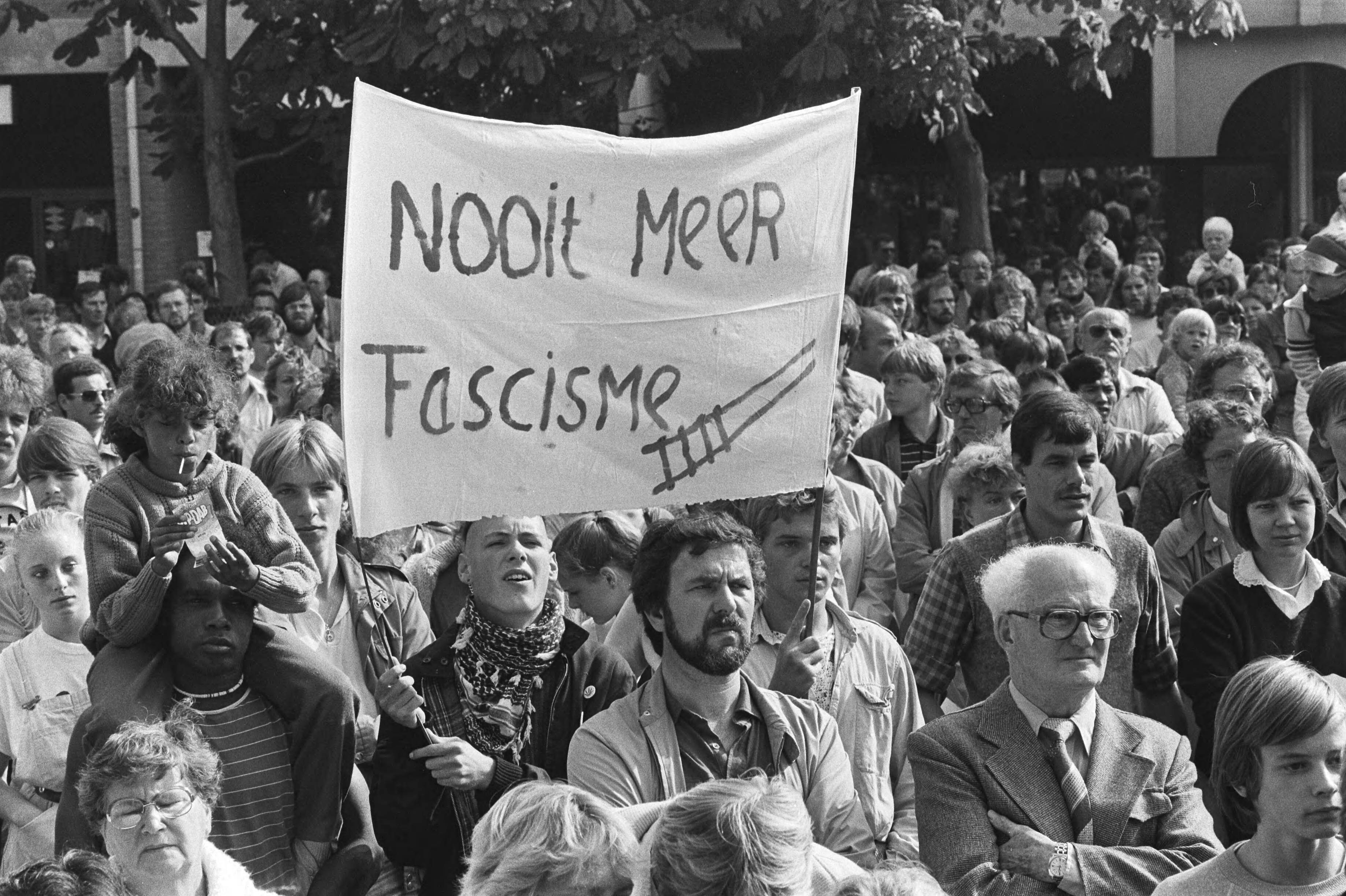 Manifestatie op markt Almere tegen de Centrumpartij, na gemeenteraadsverkiezingen — Spandoek "Nooit meer fascisme" — Foto: Antonisse, Marcel / Anefo. Licentie: Set B: Rechtenvrij / Publiek Domein. Bron: Nationaal Archief. http://hdl.handle.net/10648/ad2e4c34-d0b4-102d-bcf8-003048976d84