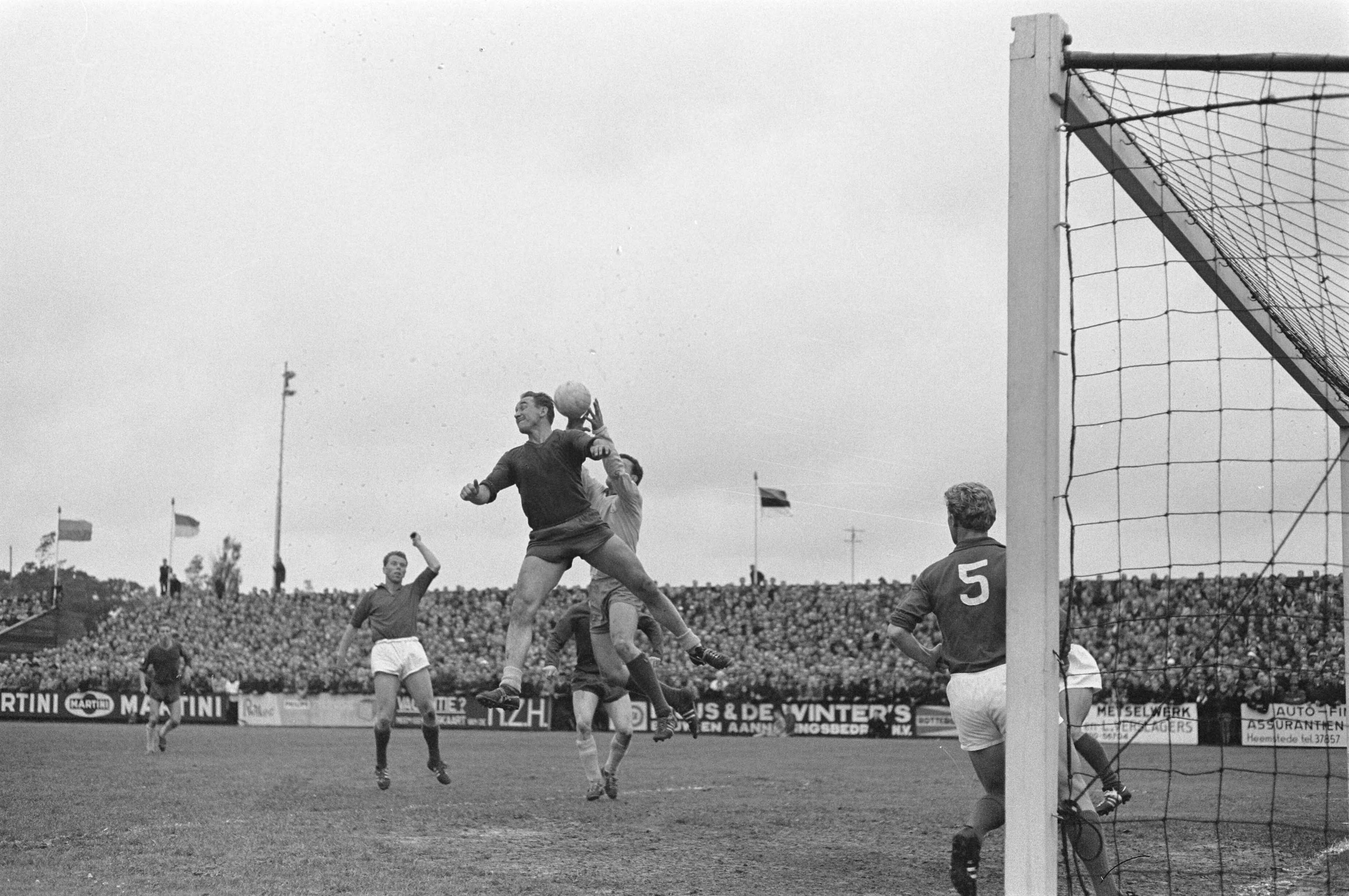 Fotocollectie Anefo — Voetbal. Promotiewedstrijd voor 1e divisie. Haarlem tegen VSV 2-2 na verlenging. Henk Angenent van Haarlem probeert te koppen. Keeper Stuy van VSV grijpt bal — Foto: Pot, Harry / Anefo. Licentie: Set B: Rechtenvrij / Publiek Domein. Bron: Nationaal Archief. http://hdl.handle.net/10648/aa3b6f66-d0b4-102d-bcf8-003048976d84