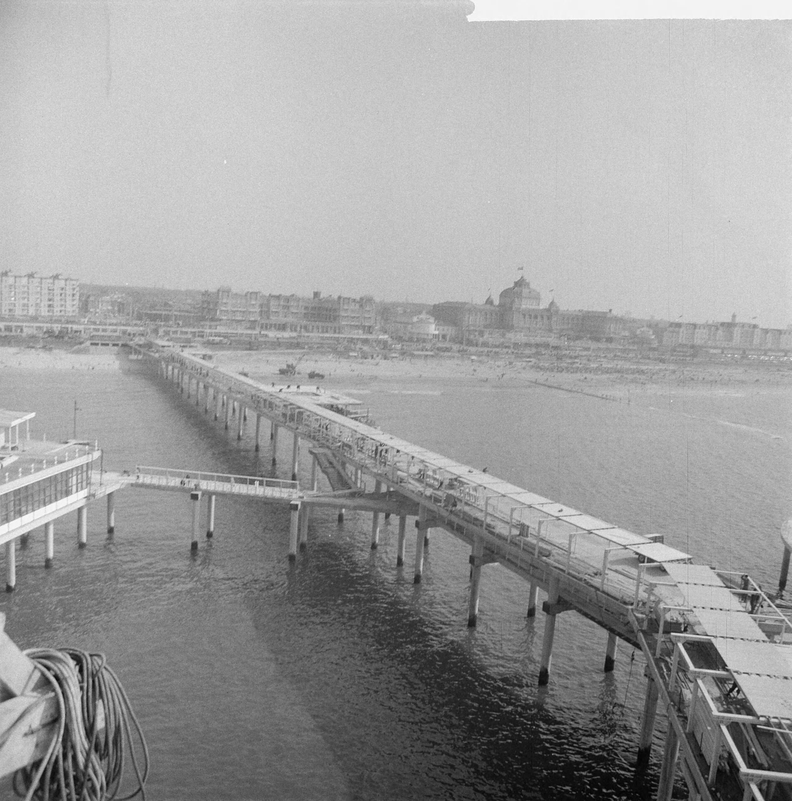 Fotocollectie Anefo — Werkzaamheden Pier te Scheveningen. Overzicht Pier naar het strand — Foto: Nijs, Jac. de / Anefo. Licentie: Set B: Rechtenvrij / Publiek Domein. Bron: Nationaal Archief. http://hdl.handle.net/10648/a9d0f3fc-d0b4-102d-bcf8-003048976d84