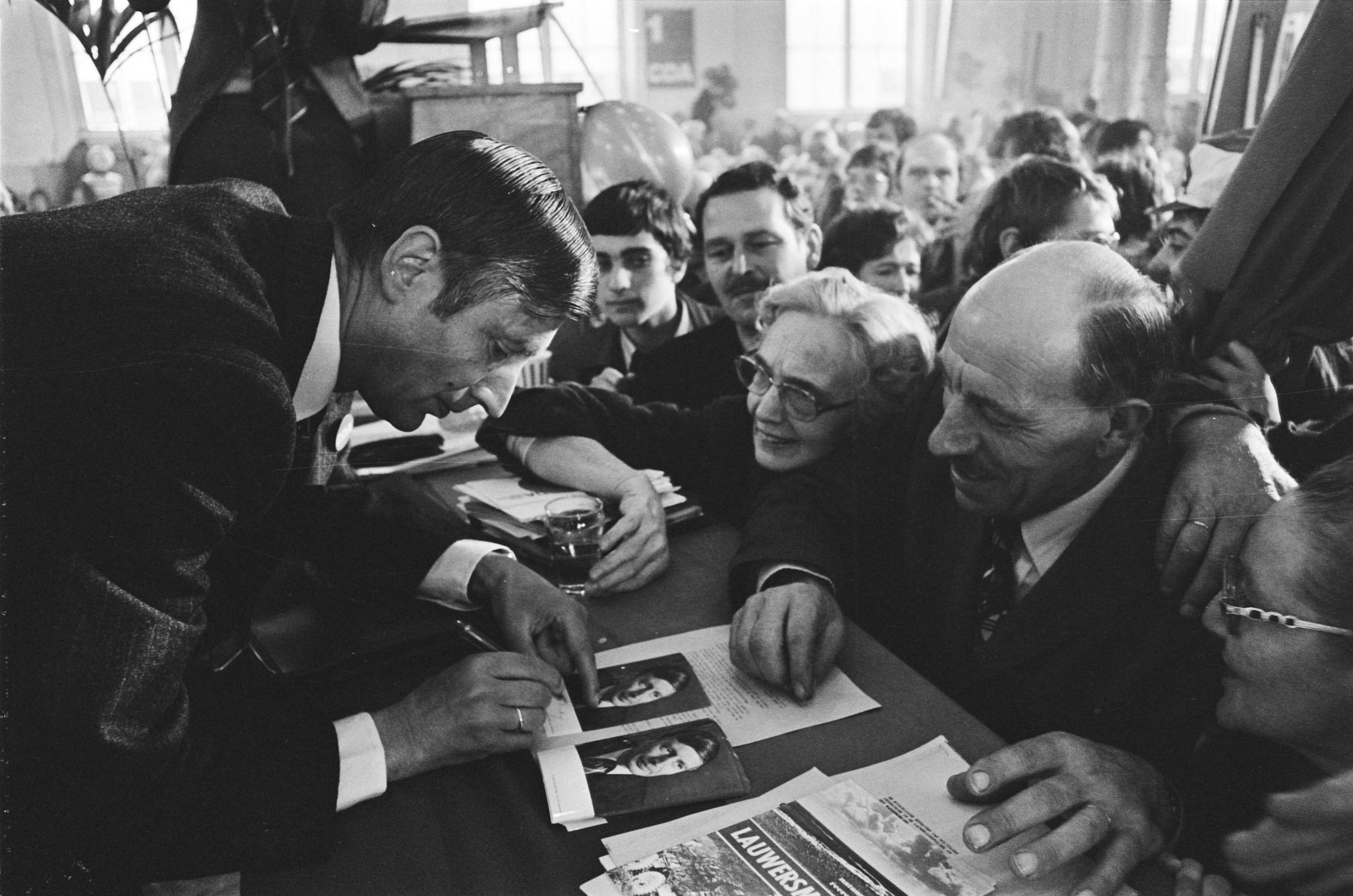 Fotocollectie Anefo — CDA verkiezingsbijeenkomst in Leeuwarden; Van Agt zet handtekeningen op fotos voor bewonderaars — Foto: Verhoeff, Bert / Anefo. Licentie: Set B: Rechtenvrij / Publiek Domein. Bron: Nationaal Archief. http://hdl.handle.net/10648/acaec0ae-d0b4-102d-bcf8-003048976d84