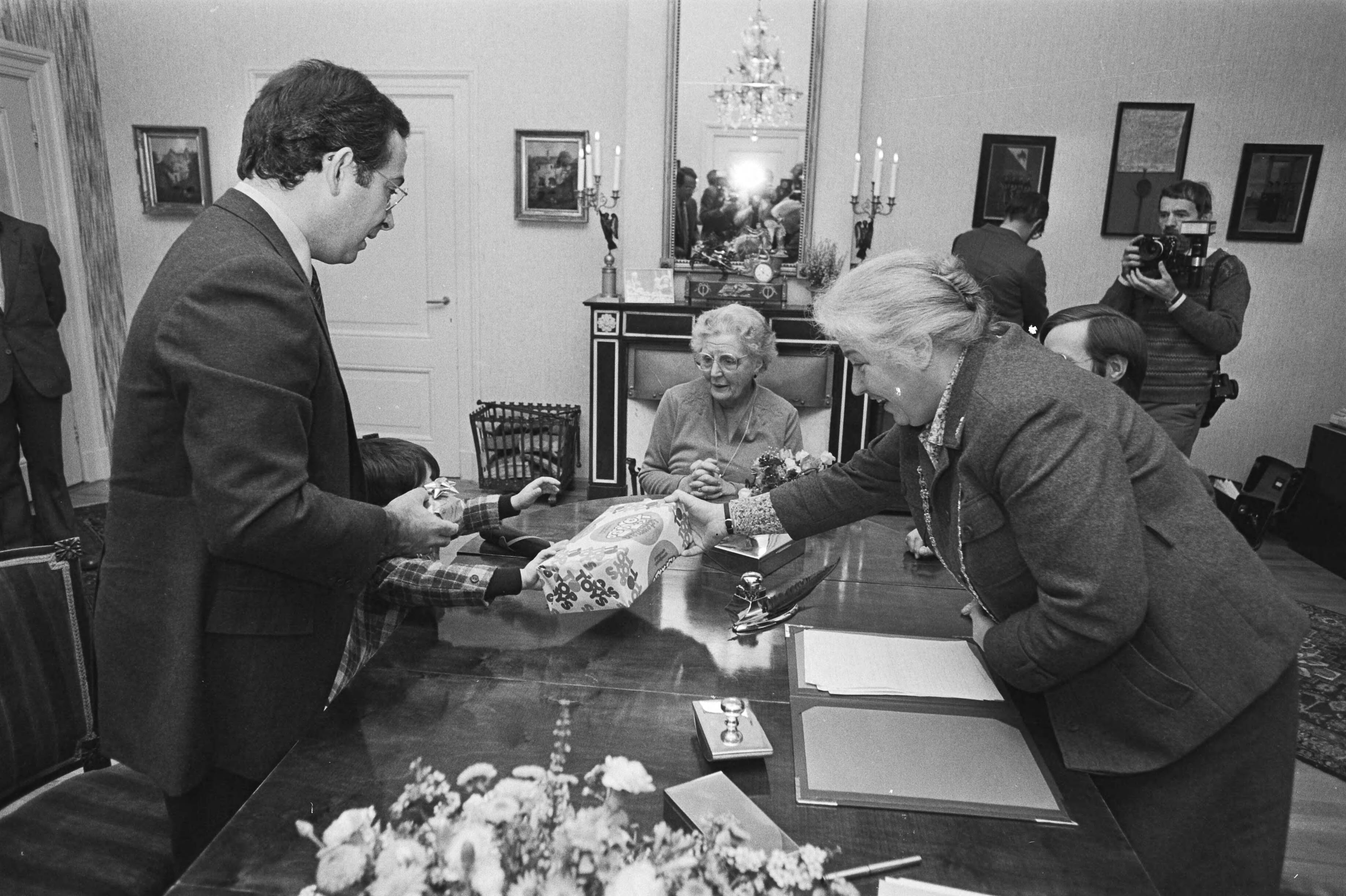 Aangifte van de geboorte van een dochter van Christina door Jorge Guillermo op het stadhuis te Utrecht — Burgemeester Vos-van Gortel overhandigt Jorge Guillermo een geschenk — Foto: Croes, Rob C. / Anefo. Licentie: Set B: Rechtenvrij / Publiek Domein. Bron: Nationaal Archief. http://hdl.handle.net/10648/ad06243e-d0b4-102d-bcf8-003048976d84