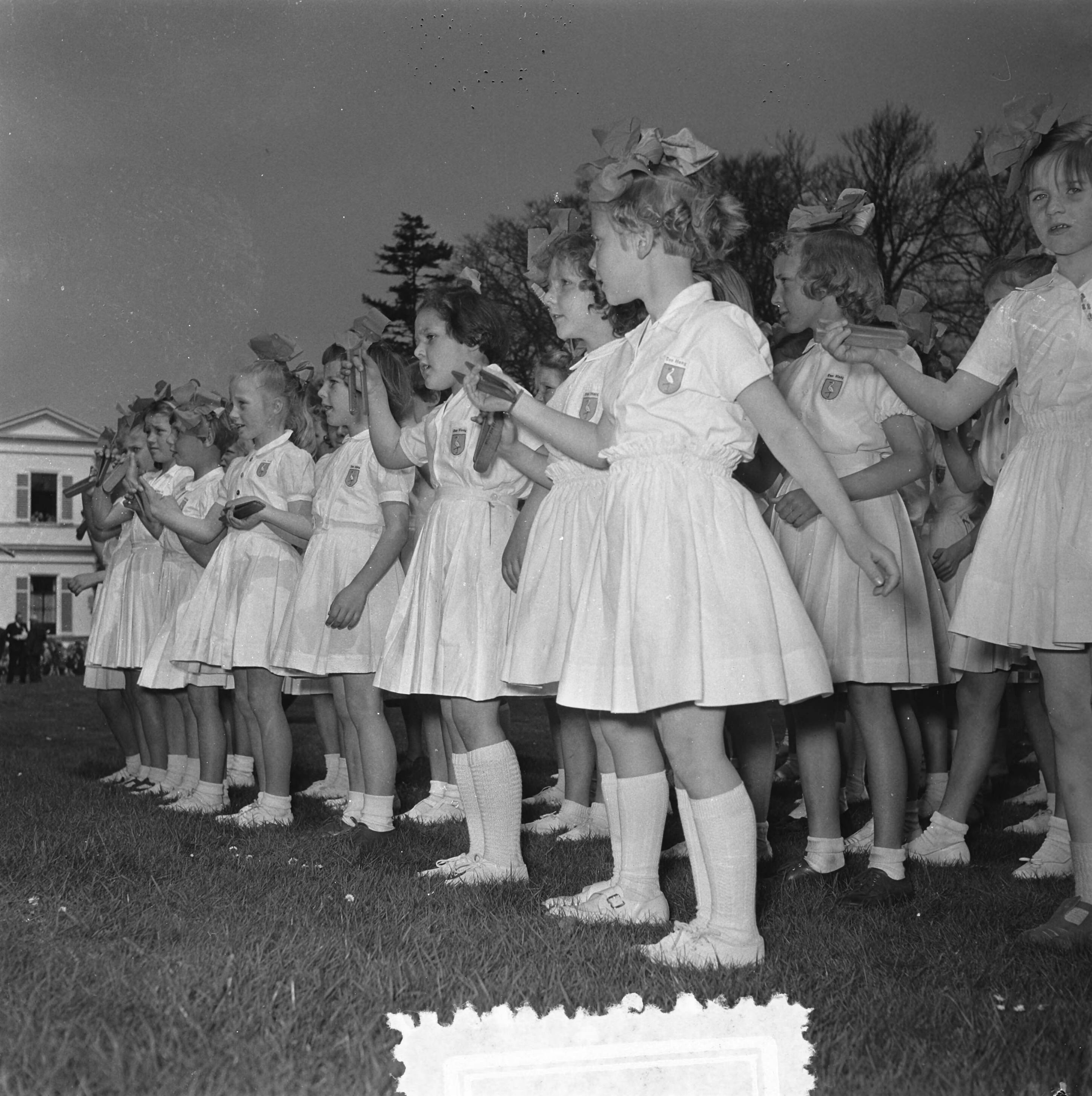 Koninginnedag 1954 — Koninginnedag. Defilé op paleis Soestdijk. Kleppermeisjes — Foto: Noske, J.D. / Anefo. Licentie: Set B: Rechtenvrij / Publiek Domein. Bron: Nationaal Archief. http://hdl.handle.net/10648/a921292c-d0b4-102d-bcf8-003048976d84