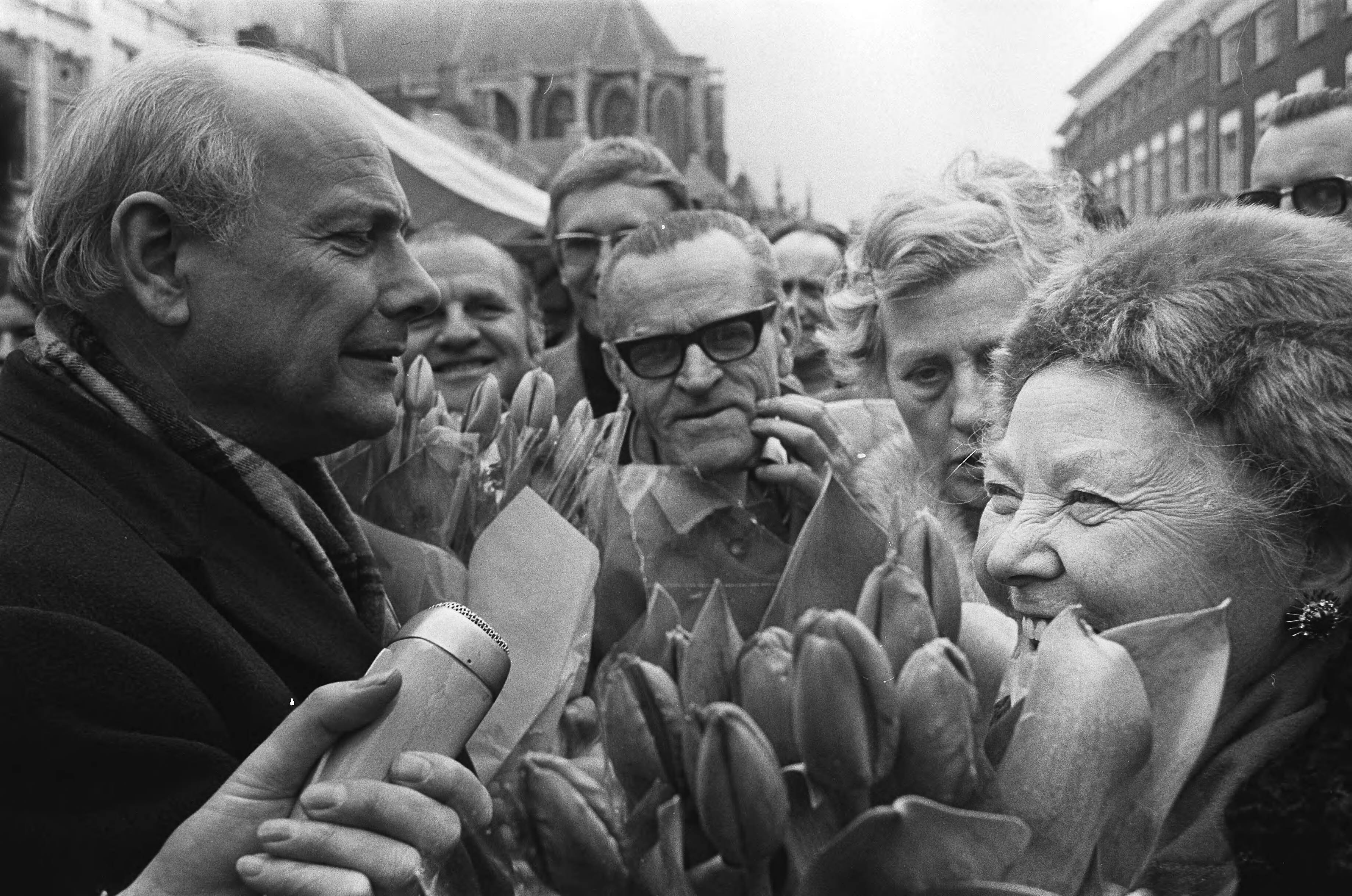 Joop den Uyl in Breda met een karavaan op verkiezingstournee voor de PvdA — Den Uyl deelt tulpen uit — Foto: Fotograaf Onbekend / Anefo. Licentie: Set B: Rechtenvrij / Publiek Domein. Bron: Nationaal Archief. http://hdl.handle.net/10648/abb8d680-d0b4-102d-bcf8-003048976d84
