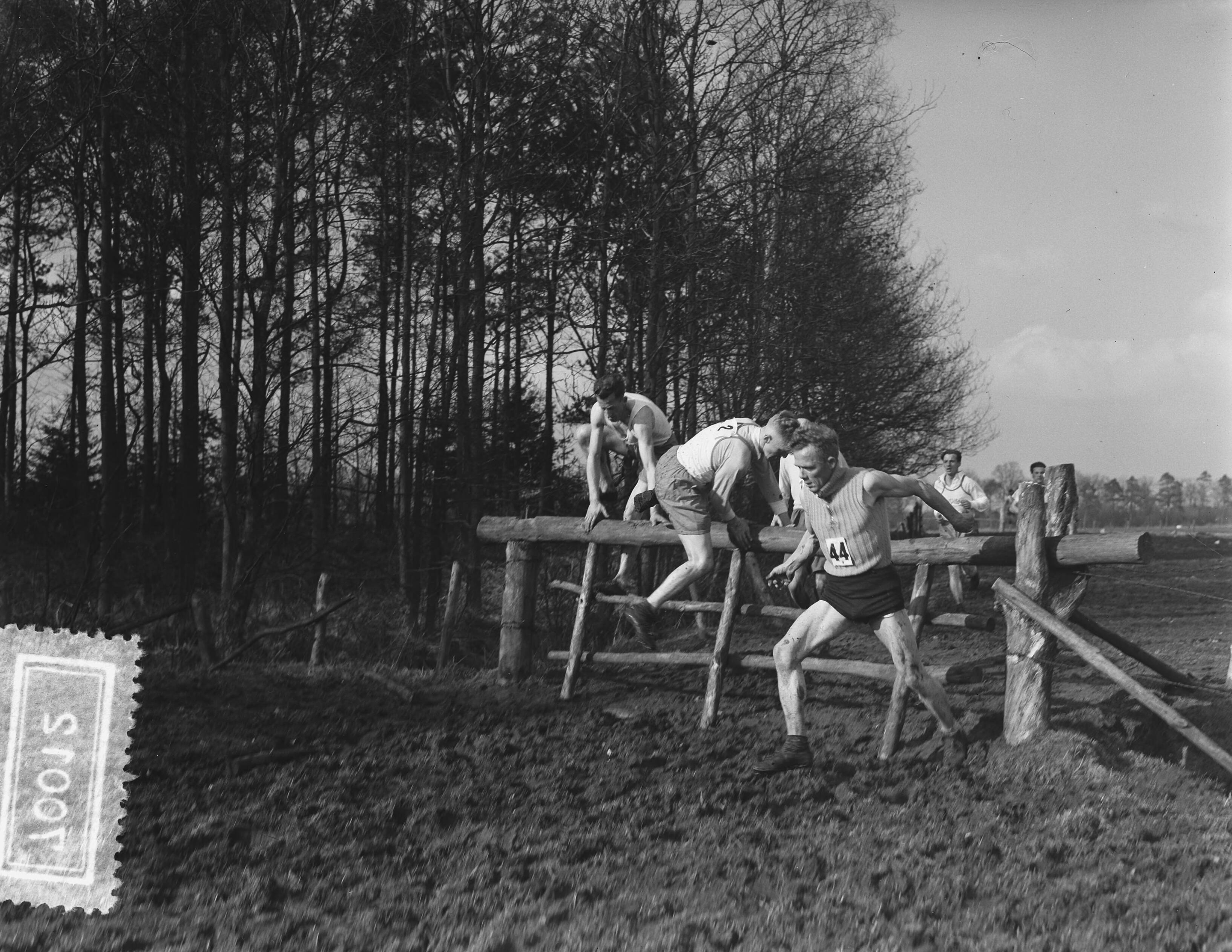 Fotocollectie Anefo — Atletiek. Crosskampioenschap van Nederland op landgoed Trippenburg te Breda. Enkele lopers nemen een hindernis (een houten hek) — Foto: Bilsen, Joop van / Anefo. Licentie: Set B: Rechtenvrij / Publiek Domein. Bron: Nationaal Archief. http://hdl.handle.net/10648/a9316c06-d0b4-102d-bcf8-003048976d84