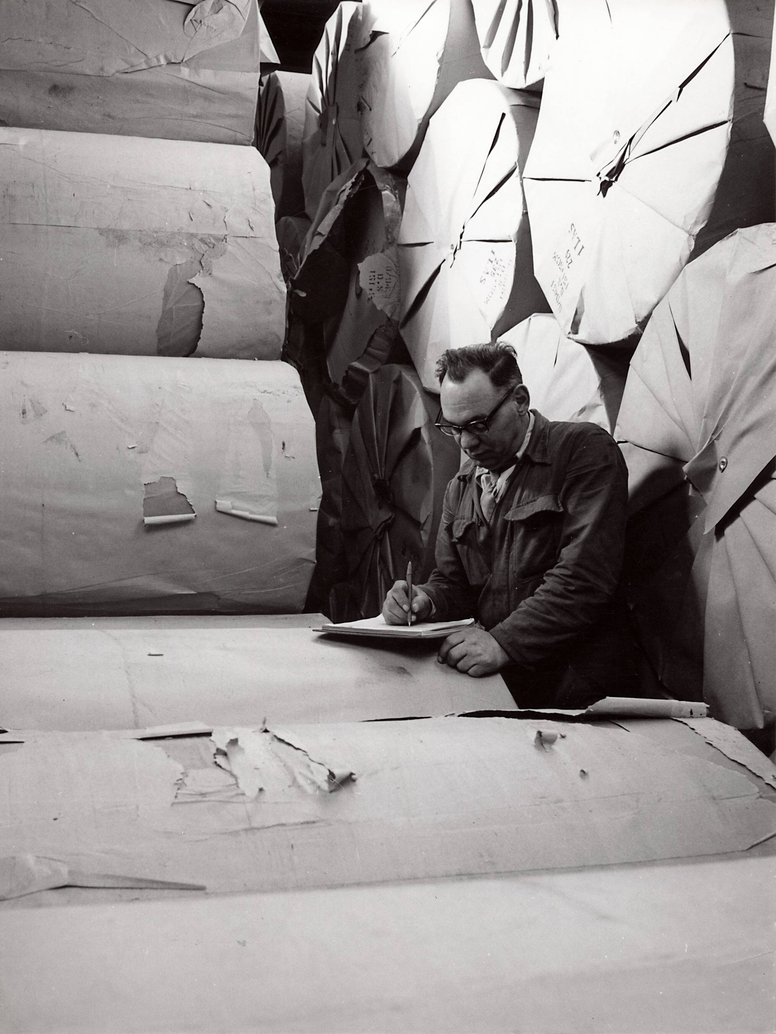 Collectie nader te bepalen — [Serie Bedrijfsvoering Spaarnestad] [man maakt notities staand tussen stapels papierrollen] — Foto: Fotograaf Onbekend / Fotobureau onbekend / Spaarnestad Photo (05887). Licentie: Set B: Rechtenvrij / Publiek Domein. Bron: Nationaal Archief. http://hdl.handle.net/10648/35429da6-42c2-a382-e063-6df0900a6686