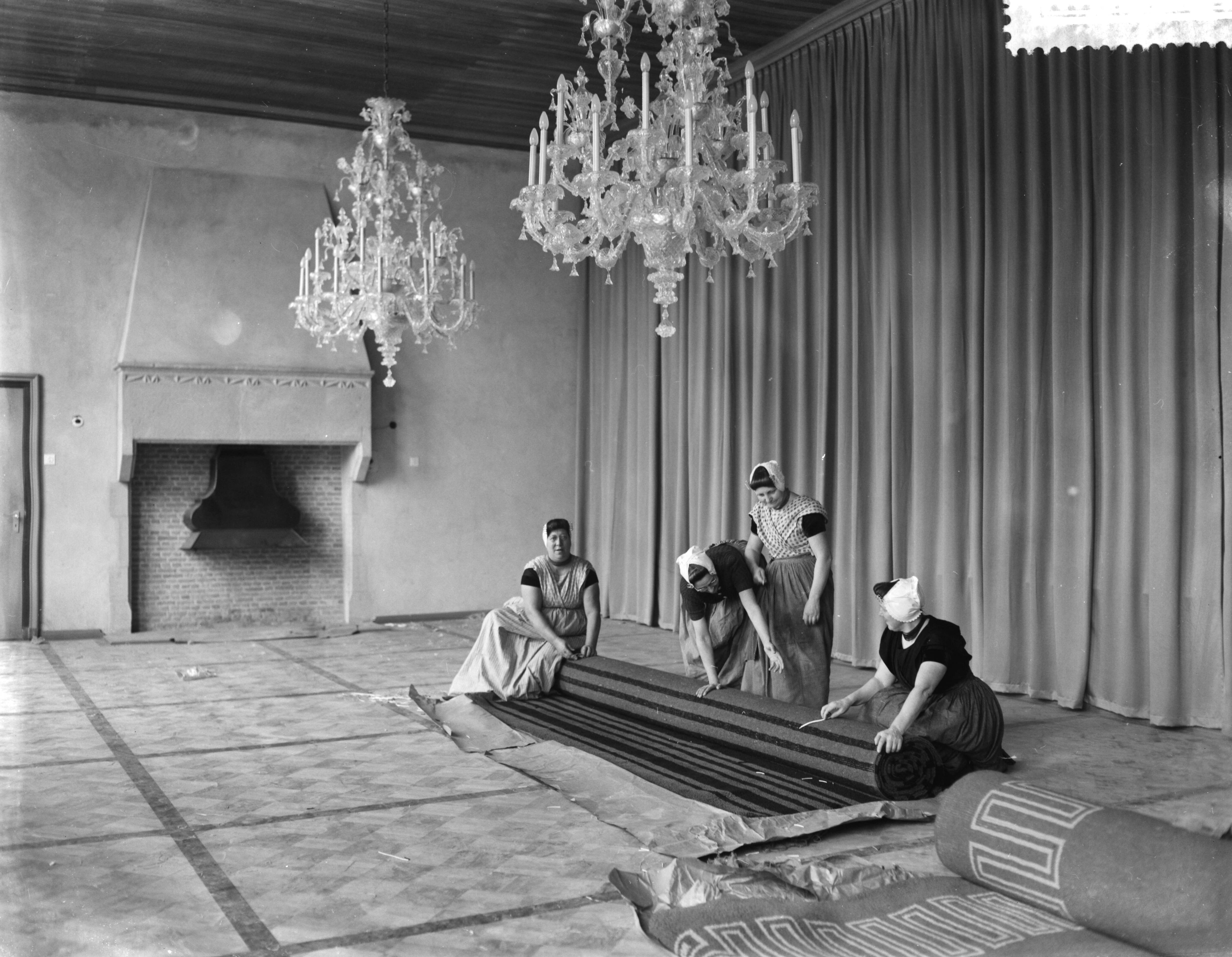 Fotocollectie Anefo — Zeeuws provinciehuis in Middelburg dat op 17 mei aanstaande door koningin Juliana geopend zal worden. Vrouwen in klederdracht zijn bezig met het inrichten der statenzaal — Foto: Bilsen, Joop van / Anefo. Licentie: Set B: Rechtenvrij / Publiek Domein. Bron: Nationaal Archief. http://hdl.handle.net/10648/a9ac72c0-d0b4-102d-bcf8-003048976d84