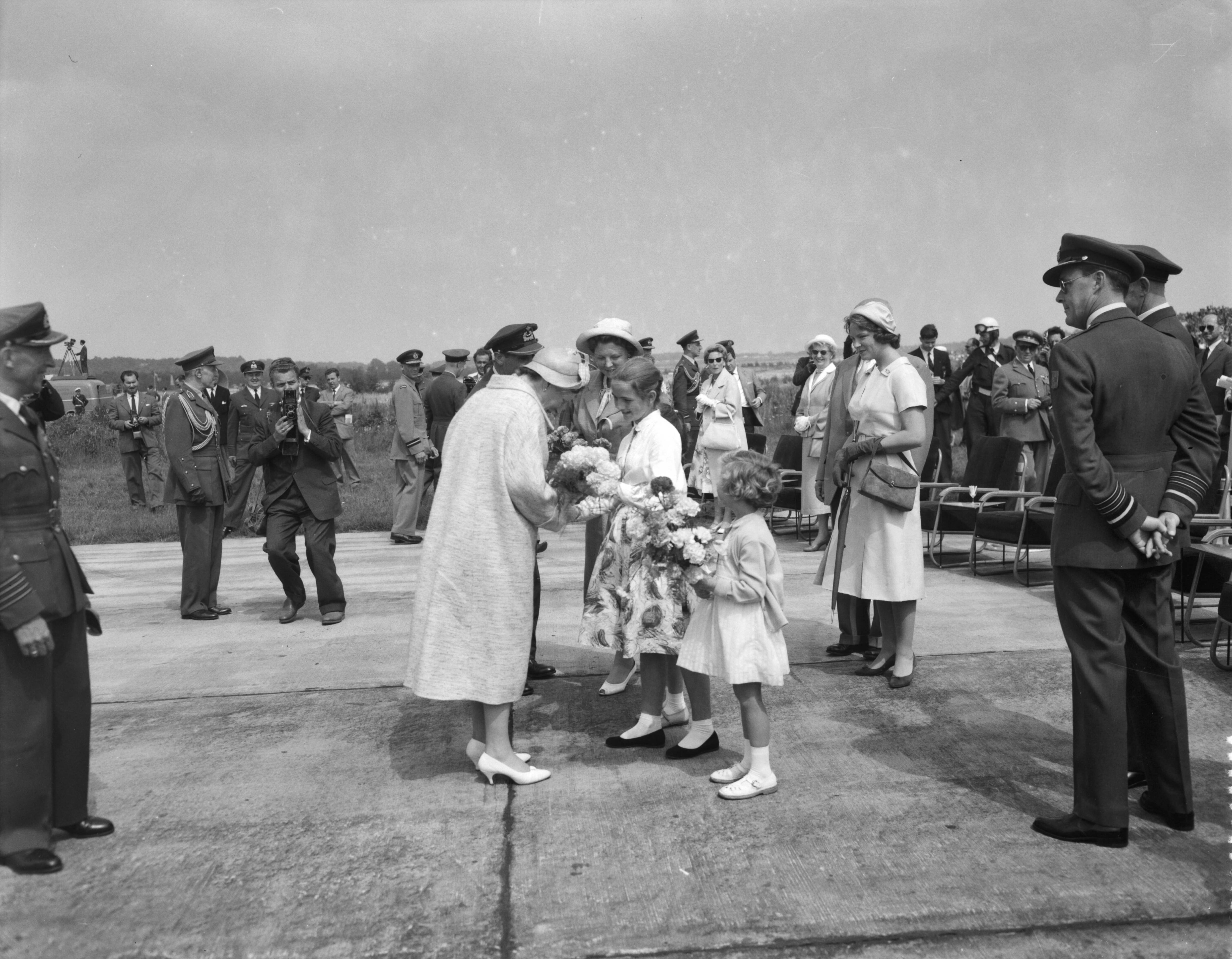 Fotocollectie Anefo — Vliegfeest op Soesterberg t.g.v. het 45-jarig bestaan van de Koninklijke Luchtmacht. Aanbieden van bloemen aan de Koninklijke familie — Foto: Noske, J.D. / Anefo. Licentie: Set B: Rechtenvrij / Publiek Domein. Bron: Nationaal Archief. http://hdl.handle.net/10648/a97fcdec-d0b4-102d-bcf8-003048976d84
