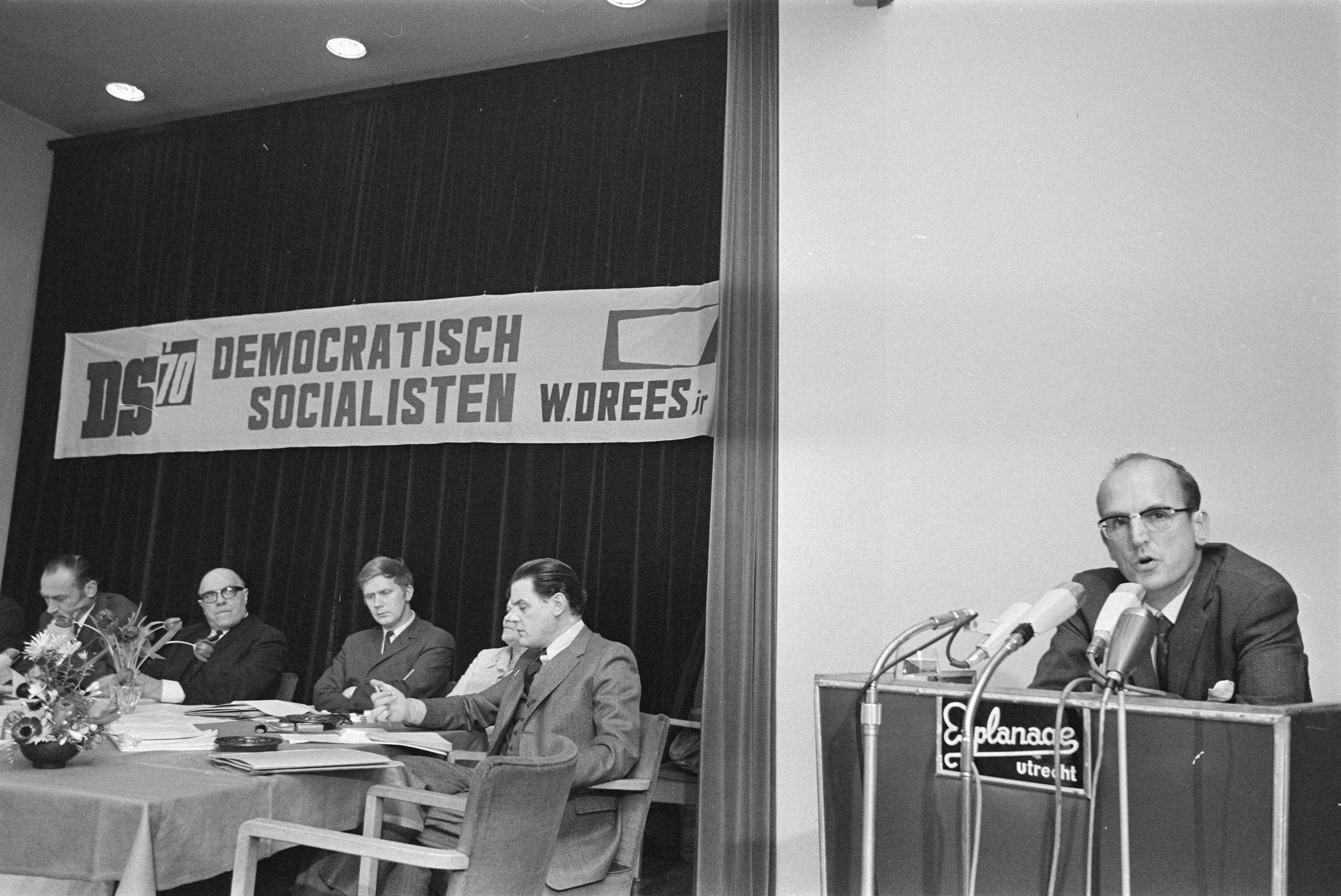 Fotocollectie Anefo — Eerste verkiezingsvergadering DS70 in Utrecht; W. Drees jr. aan het woord — Foto: Mieremet, Rob / Anefo. Licentie: Set B: Rechtenvrij / Publiek Domein. Bron: Nationaal Archief. http://hdl.handle.net/10648/abb39026-d0b4-102d-bcf8-003048976d84