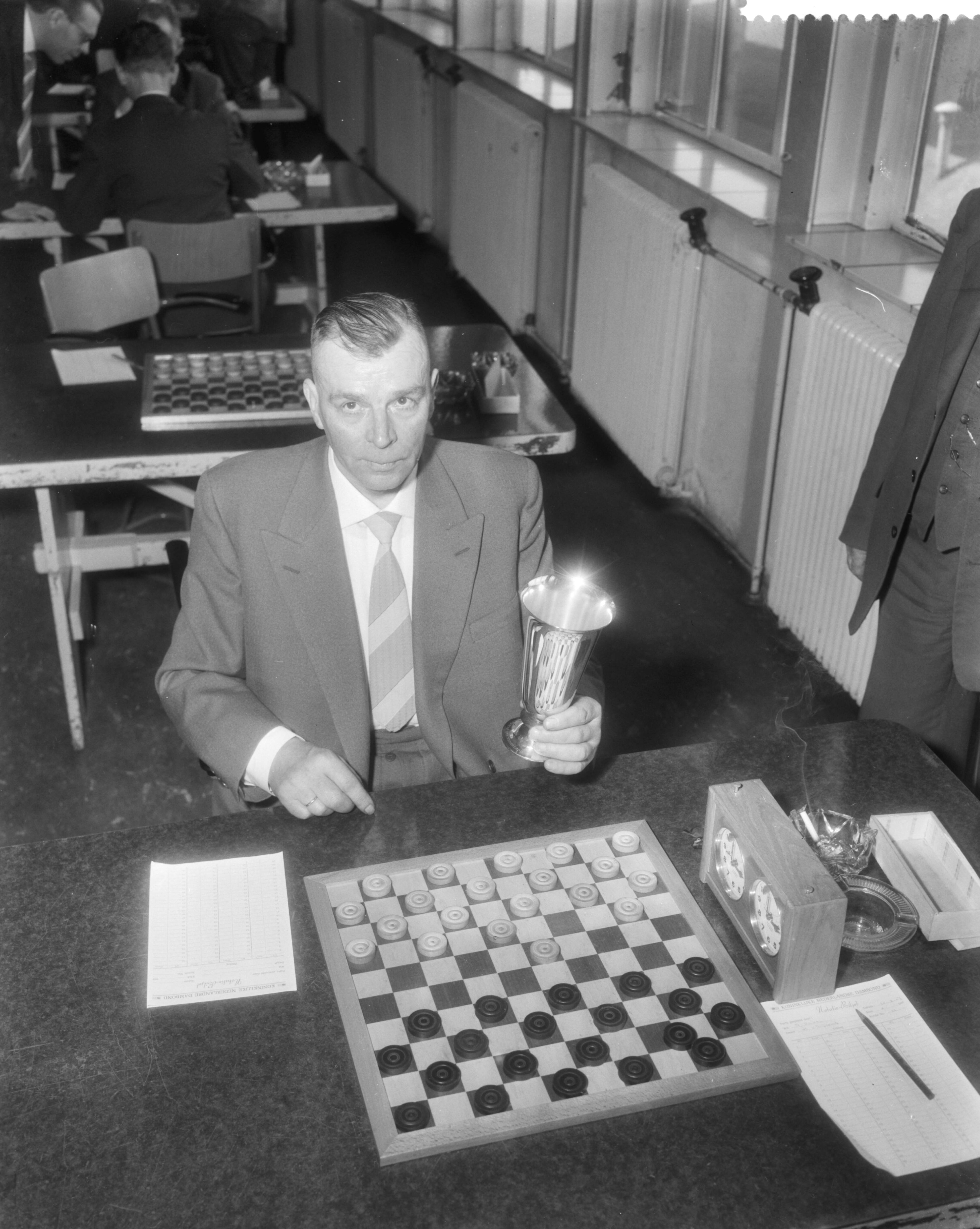 Fotocollectie Anefo — Laatste wedstrijd om het persoonlijke damkampioenschap van Nederland te Utrecht. Kampioen Baris Dukel met de beker — Foto: Pot, Harry / Anefo. Licentie: Set B: Rechtenvrij / Publiek Domein. Bron: Nationaal Archief. http://hdl.handle.net/10648/a98eabf0-d0b4-102d-bcf8-003048976d84