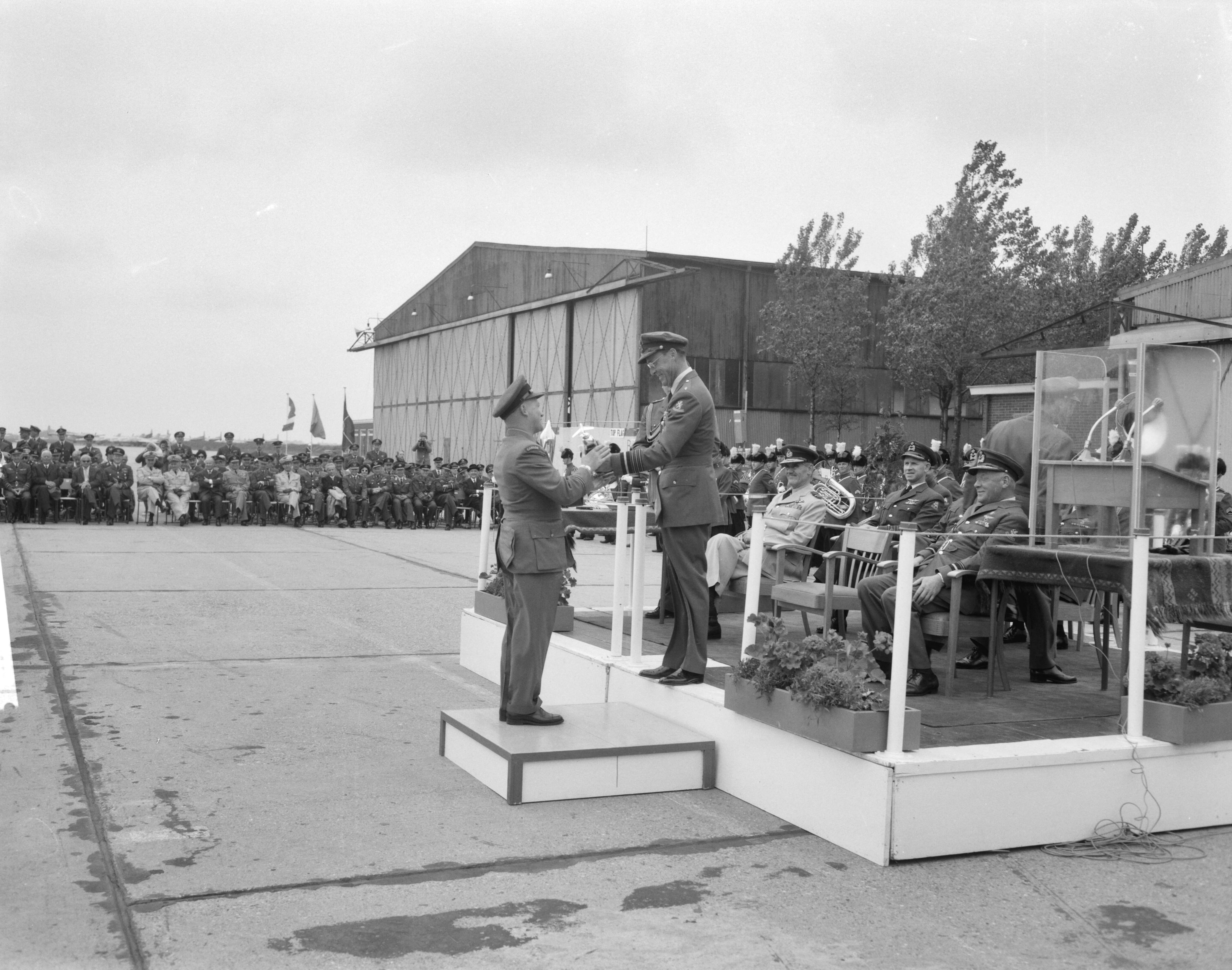 Fotocollectie Anefo — Prins Bernhard reikt in Leeuwarden prijzen uit van 5e Aircent-schietcompetitie van de NAVO luchtmacht. De Canadese "squadron-leader" krijgt de 2e prijs — Foto: Bilsen, Joop van / Anefo. Licentie: Set B: Rechtenvrij / Publiek Domein. Bron: Nationaal Archief. http://hdl.handle.net/10648/aa0d65a8-d0b4-102d-bcf8-003048976d84