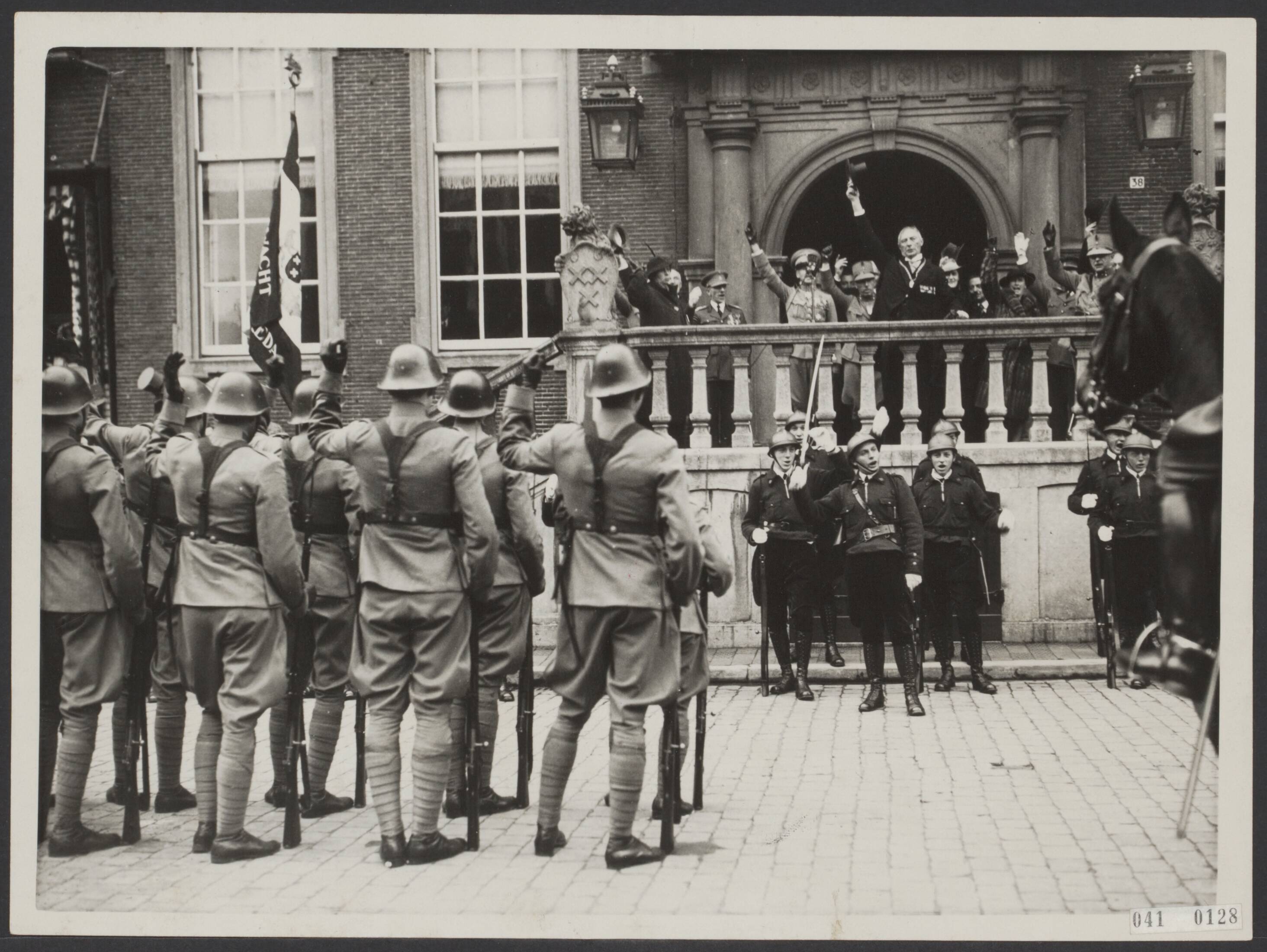 Fotocollectie Elsevier Binnenland — Herdenking van het 110-jarig bestaan van de Koninklijke Militaire Academie te Breda. Na zijn toespraak tot de jubilerende troepen brengt de burgemeester van Breda, B.W. Th. van Slobbe, een driewerf hoera uit op het Koninklijk Huis — Foto: N.V. Polygoon. Licentie: Set B: Rechtenvrij / Publiek Domein. Bron: Nationaal Archief. http://hdl.handle.net/10648/adf5fbda-d0b4-102d-bcf8-003048976d84