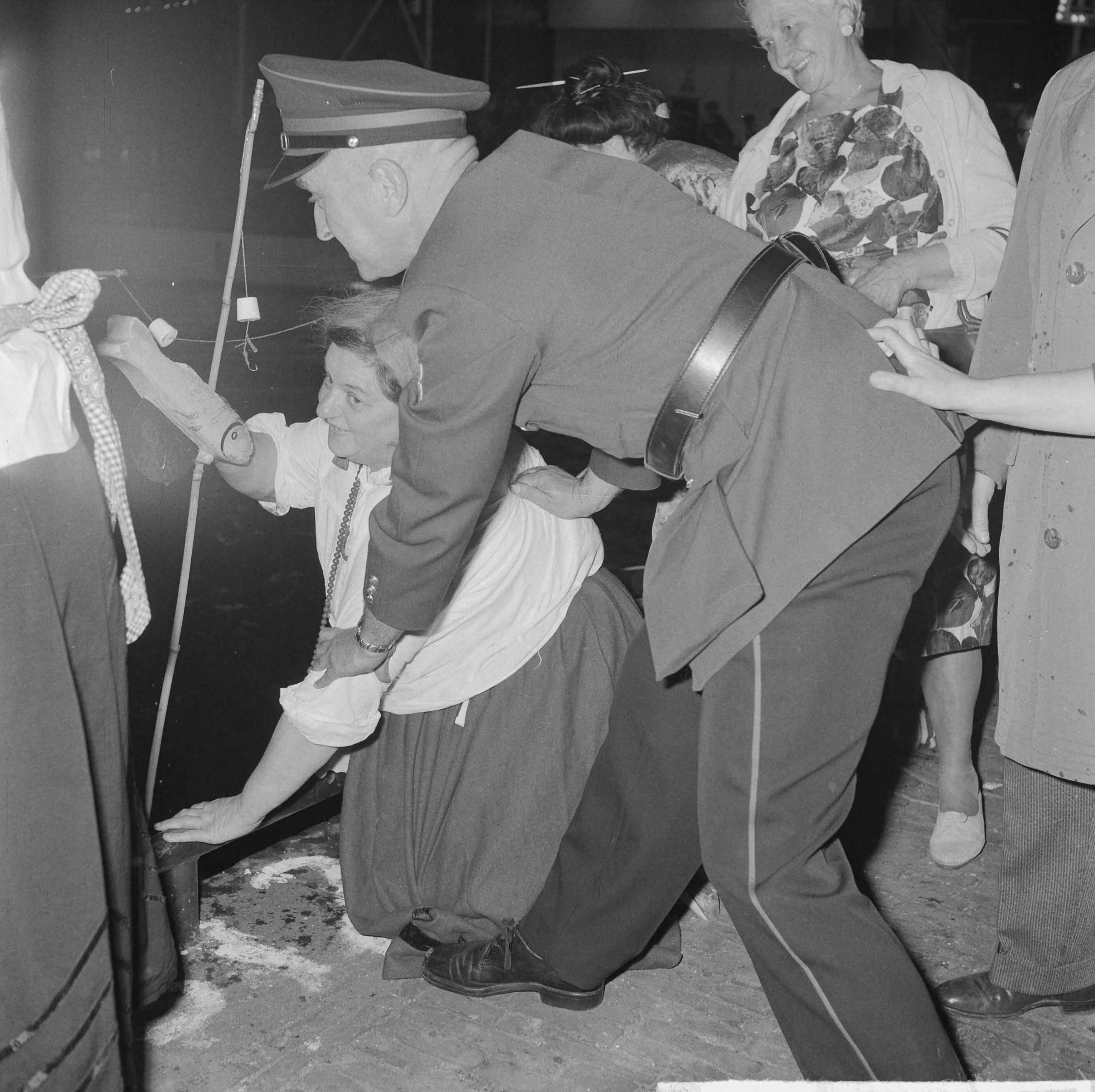 Fotocollectie Anefo — Viswedstrijd van het Jordaanse "Vrouwenviscollege" in de Brouwersgracht. Politieagent voorkomt dat Jordaanse dame in het water valt — Foto: Nijs, Jac. de / Anefo. Licentie: Set B: Rechtenvrij / Publiek Domein. Bron: Nationaal Archief. http://hdl.handle.net/10648/aa17075c-d0b4-102d-bcf8-003048976d84
