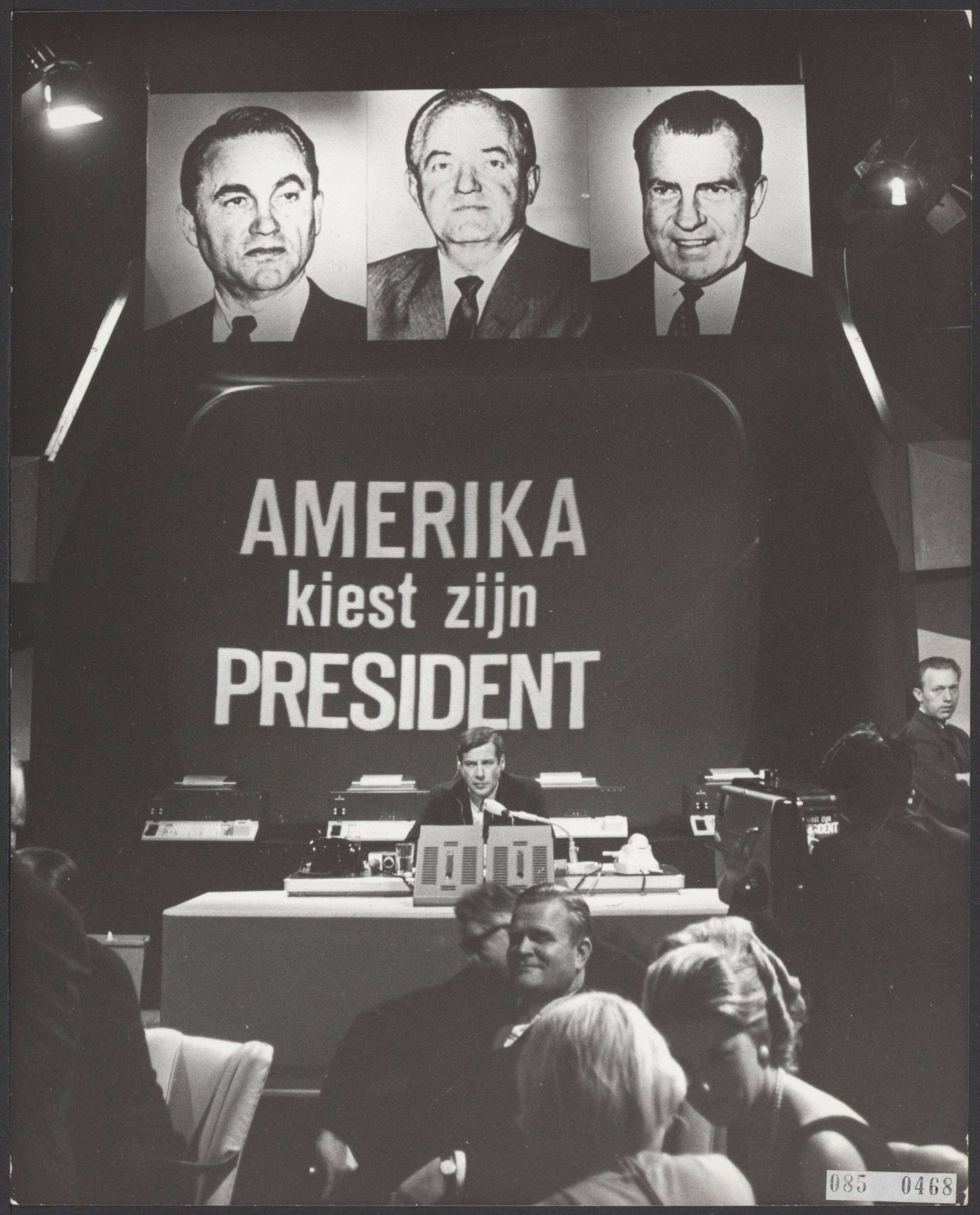Fotocollectie Elsevier Binnenland — Vanuit Studio 1 zond de NTS de gehele nacht een direct tv-programma ui met films, uitslagen en commentaris betreffende de verkiezinge in de Verenide Staten. Programmaleider W.C. Brugsma, onder de programma titel, "Amerika kiest zijn president" met daarboven de portretten van de drie presidentskandidaten — Foto: Koch, Eric / Anefo. Licentie: Set B: Rechtenvrij / Publiek Domein. Bron: Nationaal Archief. http://hdl.handle.net/10648/ae1c8944-d0b4-102d-bcf8-003048976d84
