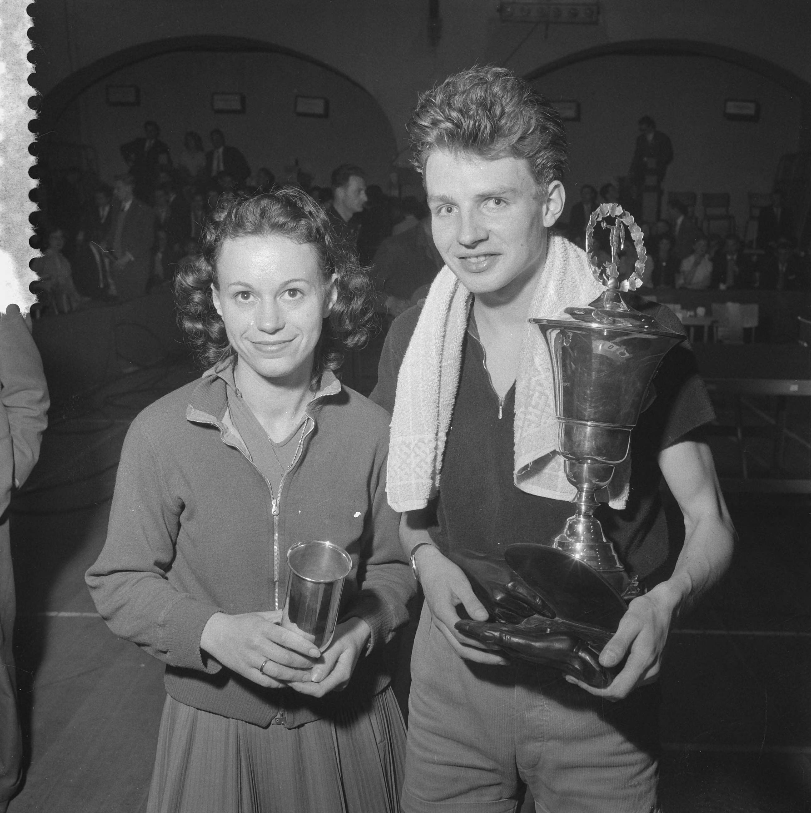 Fotocollectie Anefo — Nederlandse tafeltenniskampioenschap te Haarlem. Kampioenen Ágnes Simon en Bert Onnes tonen hun bekers — Foto: Pot, Harry / Anefo. Licentie: Set B: Rechtenvrij / Publiek Domein. Bron: Nationaal Archief. http://hdl.handle.net/10648/a9aa8faa-d0b4-102d-bcf8-003048976d84