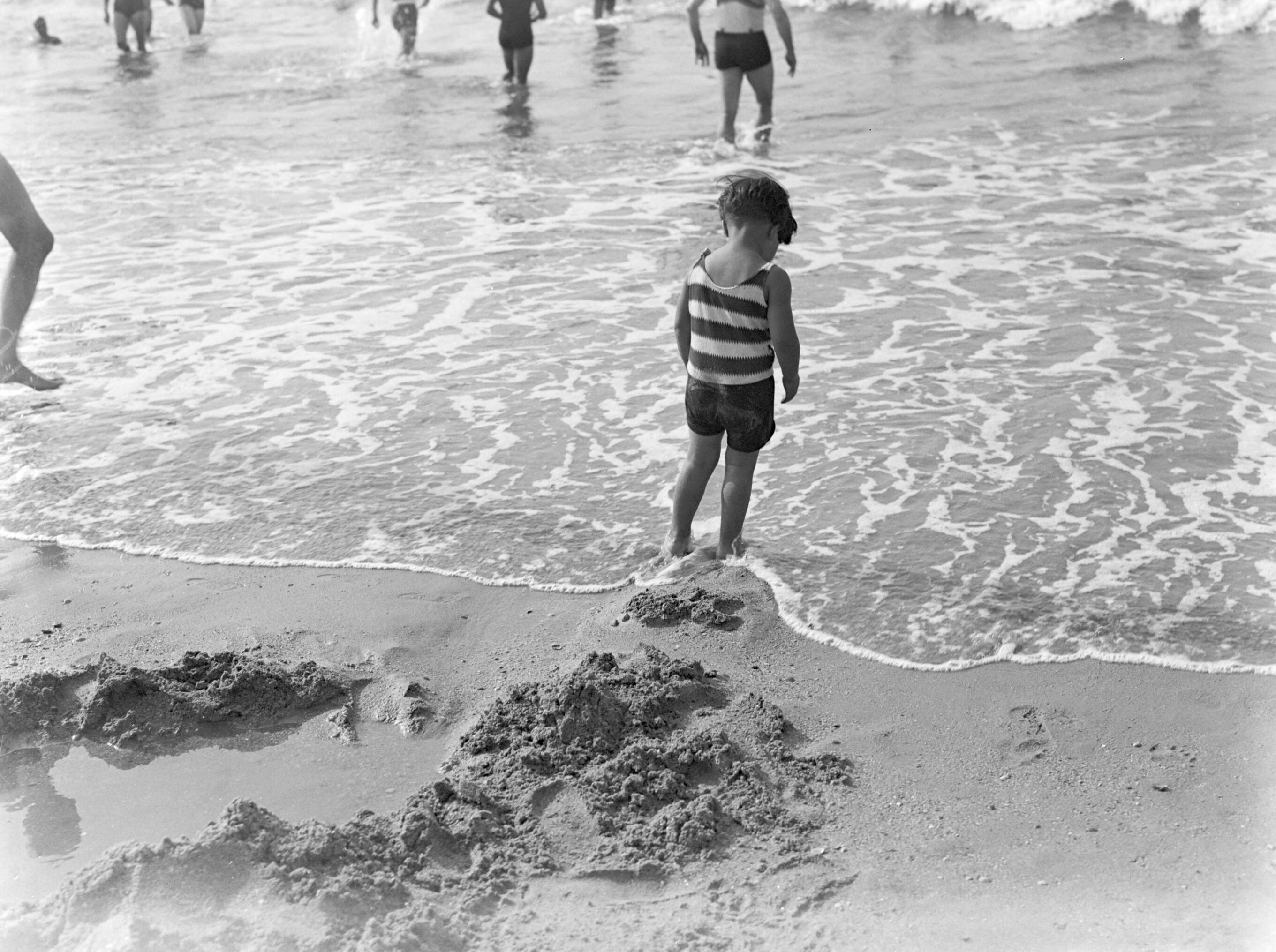 Scheveningen. — Een kind in de branding op het strand in Scheveningen — Foto: Poll, Willem van de. Licentie: Set B: Rechtenvrij / Publiek Domein. Bron: Nationaal Archief. http://hdl.handle.net/10648/ae9ac1e2-d0b4-102d-bcf8-003048976d84