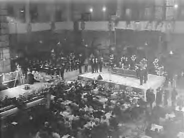 Fotocollectie Anefo — Veiling van effecten in de Grote Zaal van de Effectenbeurs ten bate van het Prinses Beatrix Poliofonds. Burgemeester Boot (Hilversum) maakt bekend dat veilingmeester Johan Bodegraven Ridder in de orde van Oranje Nassau is geworden — Foto: Pot, Harry / Anefo. Licentie: Set B: Rechtenvrij / Publiek Domein. Bron: Nationaal Archief. http://hdl.handle.net/10648/a962164e-d0b4-102d-bcf8-003048976d84