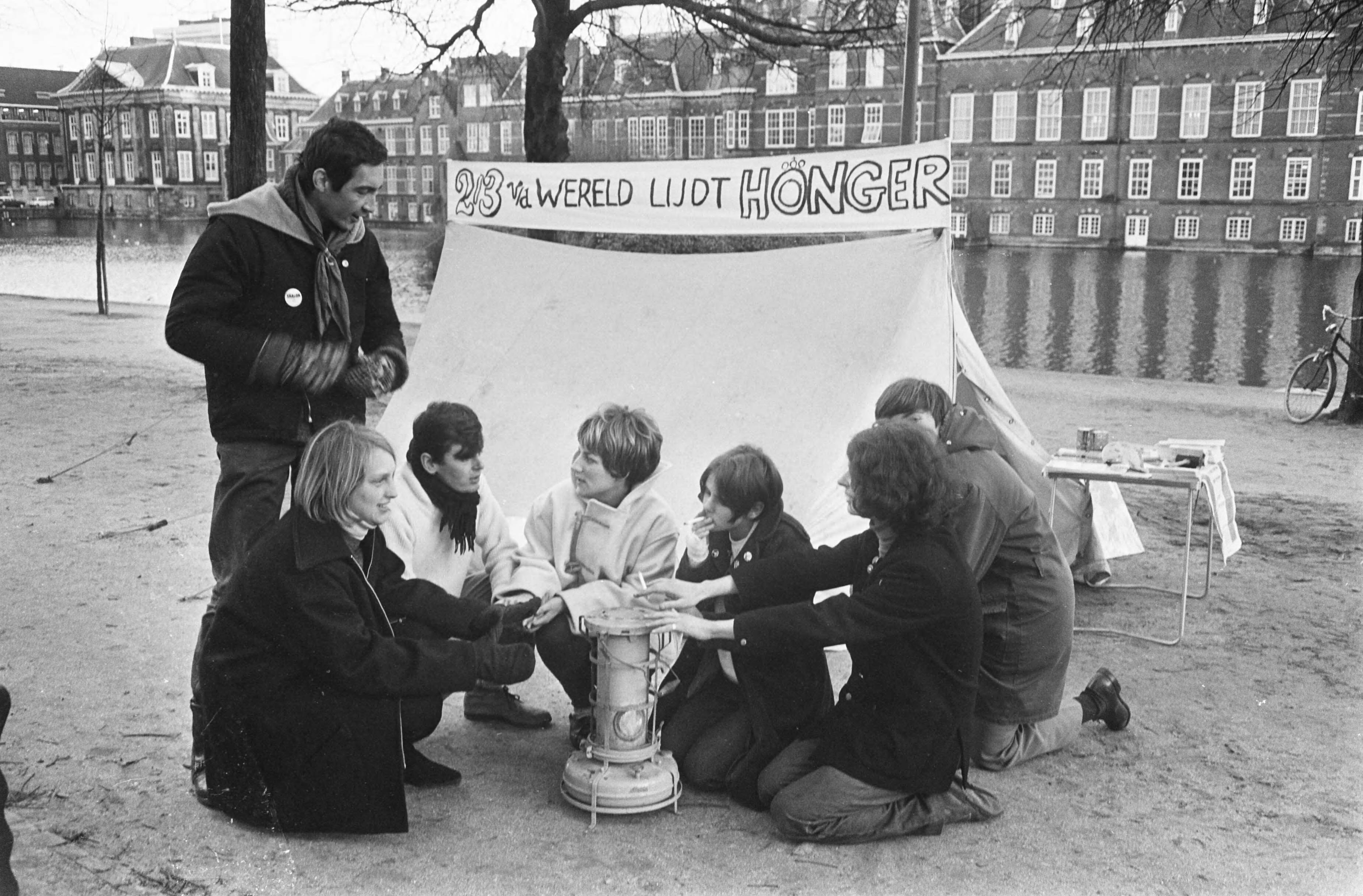 Fotocollectie Anefo — Honger Aktie van jongeren op de Lange Vijverberg in Den Haag , demonstranten met oliekacheltje — Foto: Koch, Eric / Anefo. Licentie: Set B: Rechtenvrij / Publiek Domein. Bron: Nationaal Archief. http://hdl.handle.net/10648/ab307754-d0b4-102d-bcf8-003048976d84