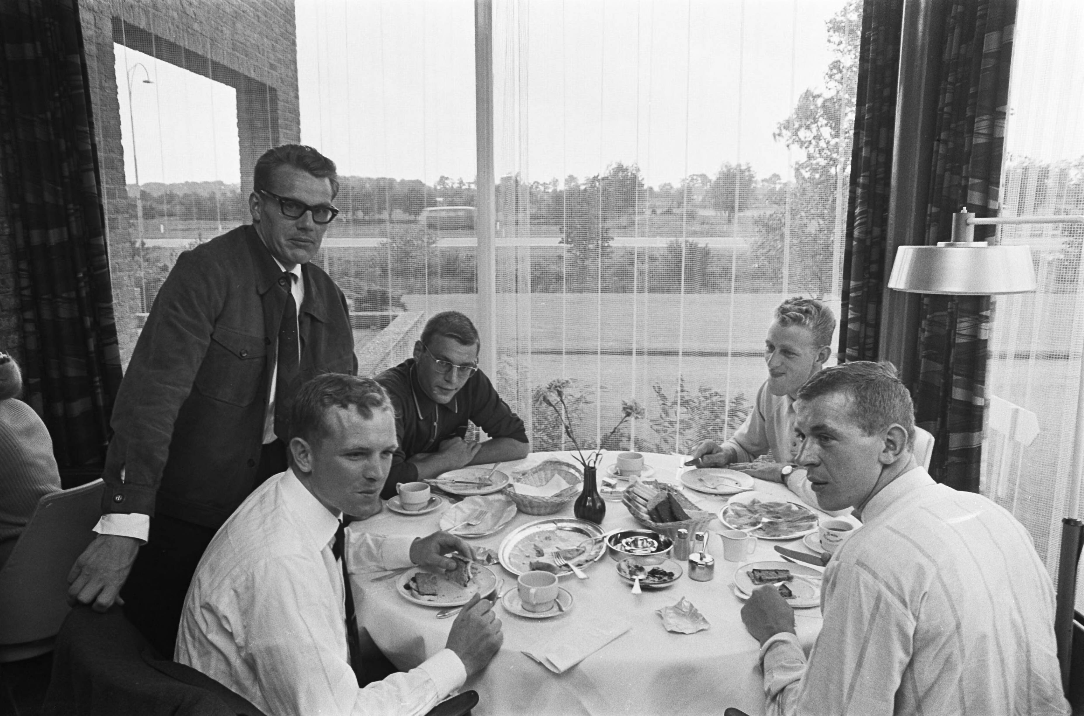 Fotocollectie Anefo — Nederlandse Tour de France ploeg uit Breda naar Vittel vertrokken. De renners aan tafel (staand Jan Janssen) — Foto: Nijs, Jac. de / Anefo. Licentie: Set B: Rechtenvrij / Publiek Domein. Bron: Nationaal Archief. http://hdl.handle.net/10648/ab4540b2-d0b4-102d-bcf8-003048976d84