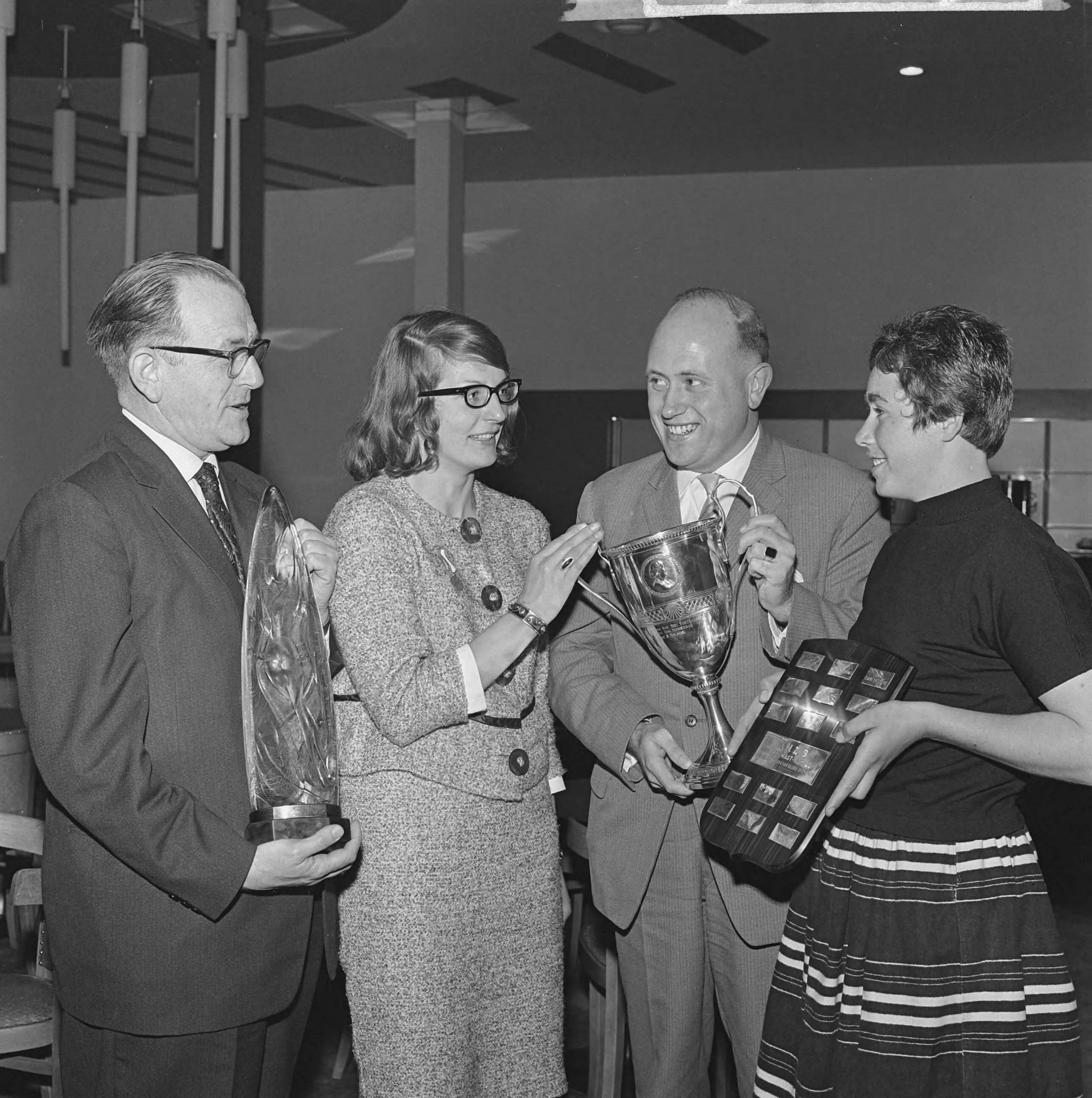 Fotocollectie Anefo — Uitreiking onderscheidingen op de jaarvergadering van de KNZB. Vlnr. Jan Armbrust, echtgenote van de overleden Uut Molenaar, leidster van de zwemvereniging Admiraal de Ruyter met de nieuwe trofee, de Uut Armbrust-Molenaar Memorial, de Groningse rugslagzwemster Corrie Winkel kreeg de gouden penning van verdienste, aftredend voorzitter van de Sportcommissie S. Bolman met de Moeder Triebels beker en Adrie Lasterie, vrije slagzwemster van de zwemvereniging Naarden met het Van der Mastschild en een gouden medaille — Foto: Koch, Eric / Anefo. Licentie: Set B: Rechtenvrij / Publiek Domein. Bron: Nationaal Archief. http://hdl.handle.net/10648/aa0461ce-d0b4-102d-bcf8-003048976d84
