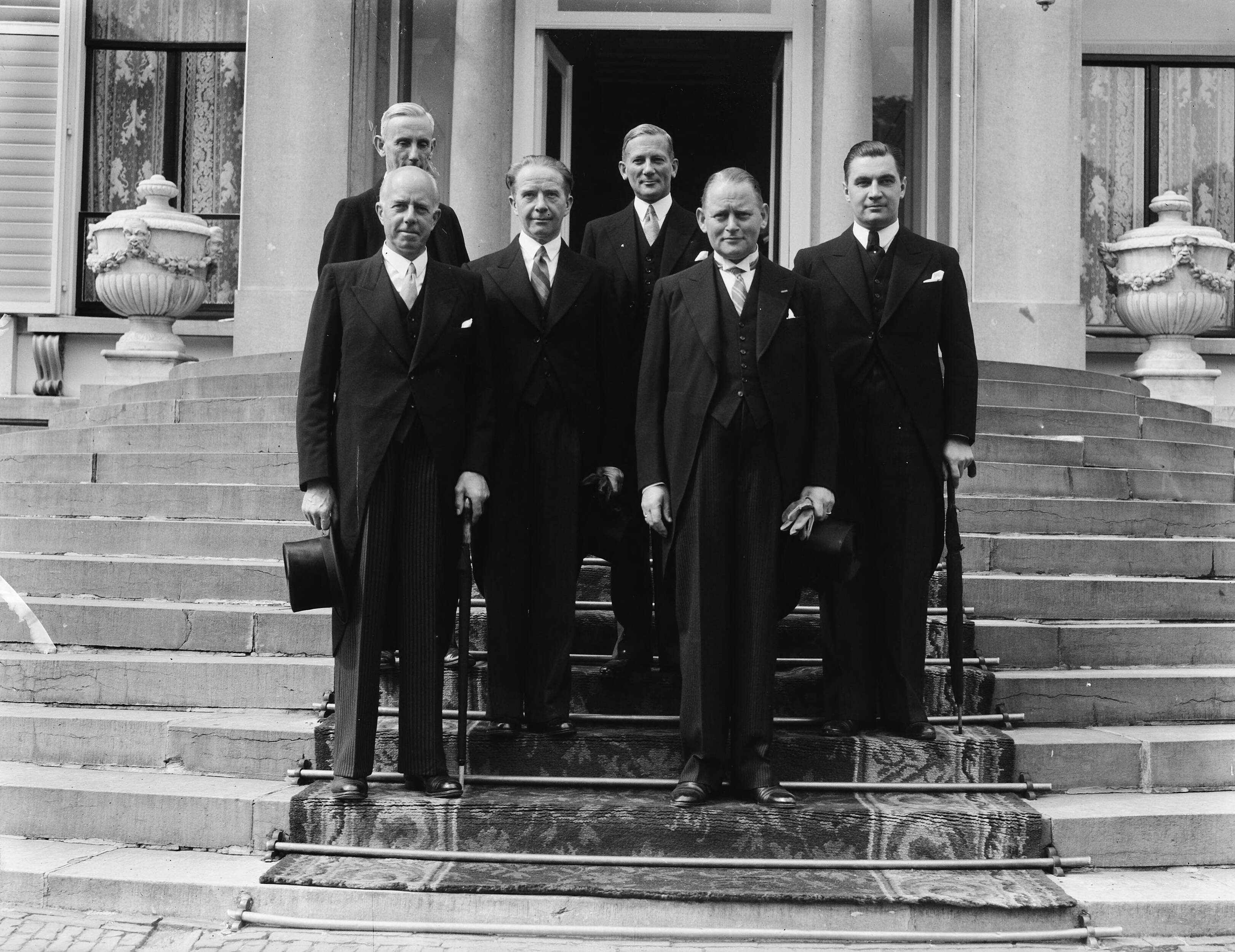 Fotocollectie Anefo — De Prinses-Regentes, Prinses Juliana, heeft ten Paleize Soestdijk de nieuwe ministers beëdigd. Na afloop poseerden de ministers met uitzondering van de heer Van Schaik, die nog enige tijd in het Paleis verbleef, op het bordes. Van rechts naar links: Mr. E. M. J. A. Sassen, Mr. D. U. Stikker, Mr. W. F. Schokking, Prof. dr. F. J. Th. Rutten, Mr. Th. R. J. Wijers en Mr. A. M. Joekes. — Foto: Merk, Ben / Anefo. Licentie: Set B: Rechtenvrij / Publiek Domein. Bron: Nationaal Archief. http://hdl.handle.net/10648/a8bae932-d0b4-102d-bcf8-003048976d84
