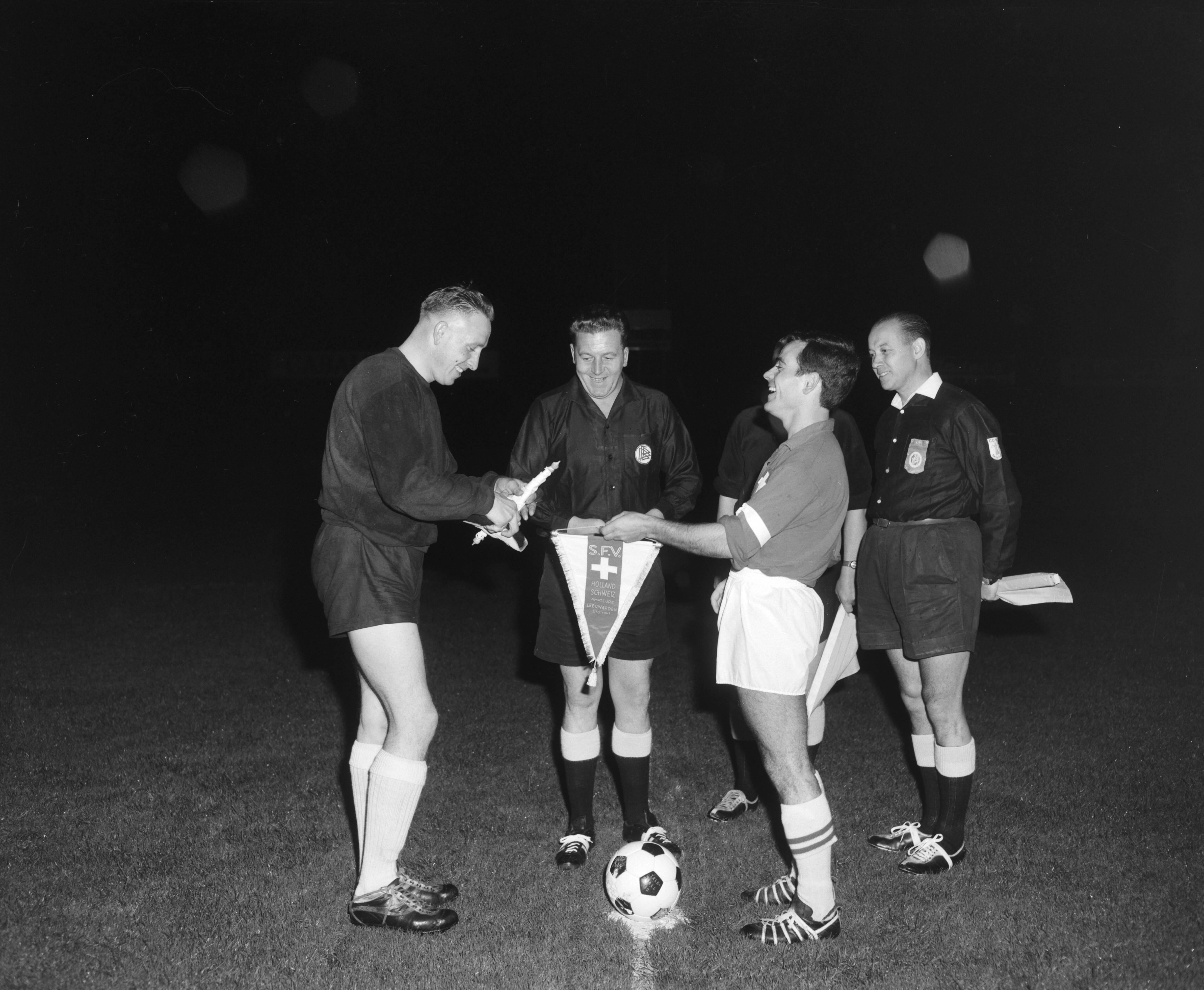 Fotocollectie Anefo — Voetbal. Nederland (zaterdagmiddagamateurs) tegen Zwitserland 4-3. De toss, links keeper Woudsma — Foto: Bilsen, Joop van / Anefo. Licentie: Set B: Rechtenvrij / Publiek Domein. Bron: Nationaal Archief. http://hdl.handle.net/10648/aa4809ba-d0b4-102d-bcf8-003048976d84