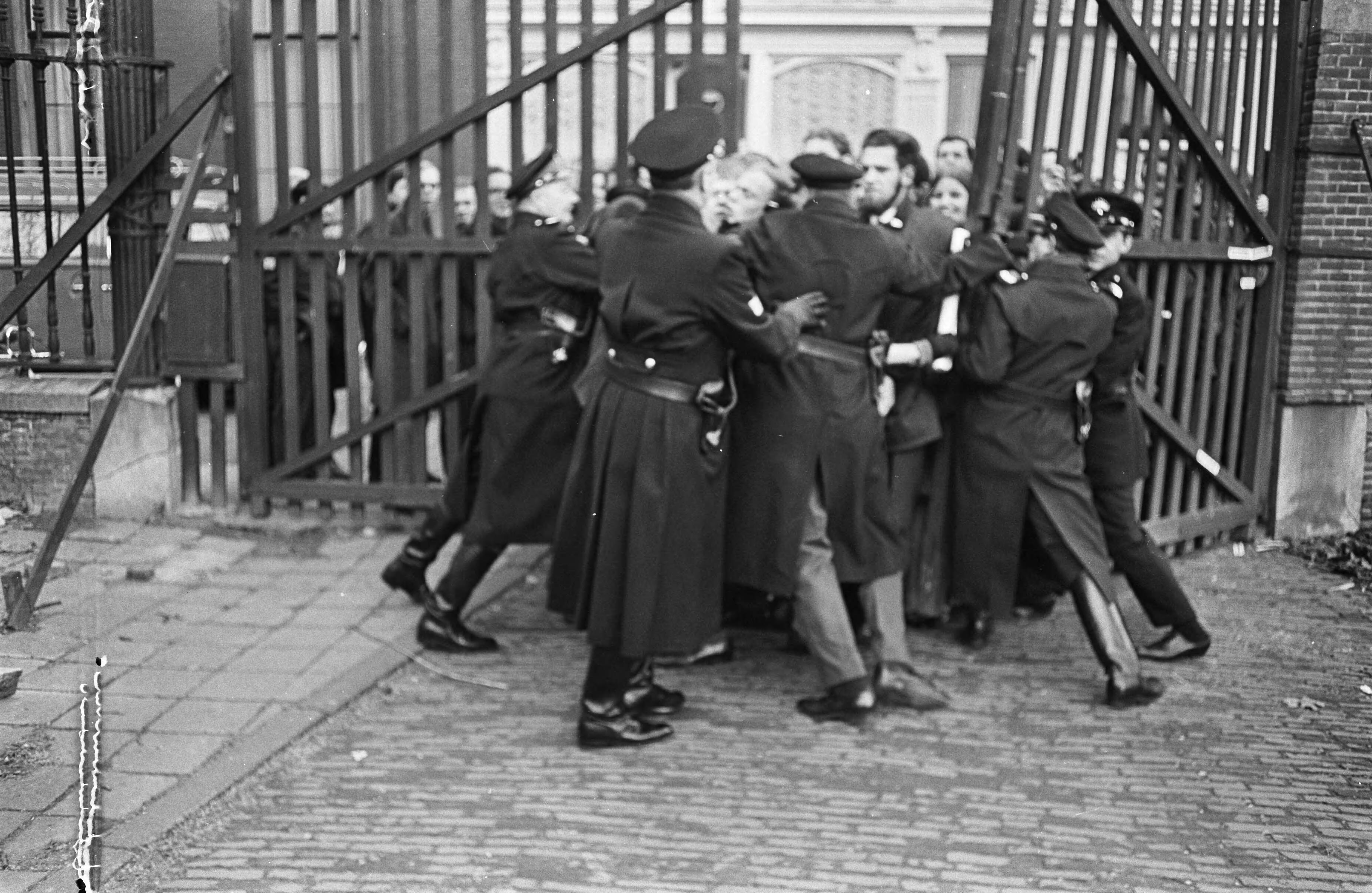Fotocollectie Anefo — Utrechtse studenten voor rechter, drie van de vier. Rijkspolitie en wachten hadden veel moeite belangstellend achter hek te houden — Foto: Koch, Eric / Anefo. Licentie: Set B: Rechtenvrij / Publiek Domein. Bron: Nationaal Archief. http://hdl.handle.net/10648/ab395afe-d0b4-102d-bcf8-003048976d84