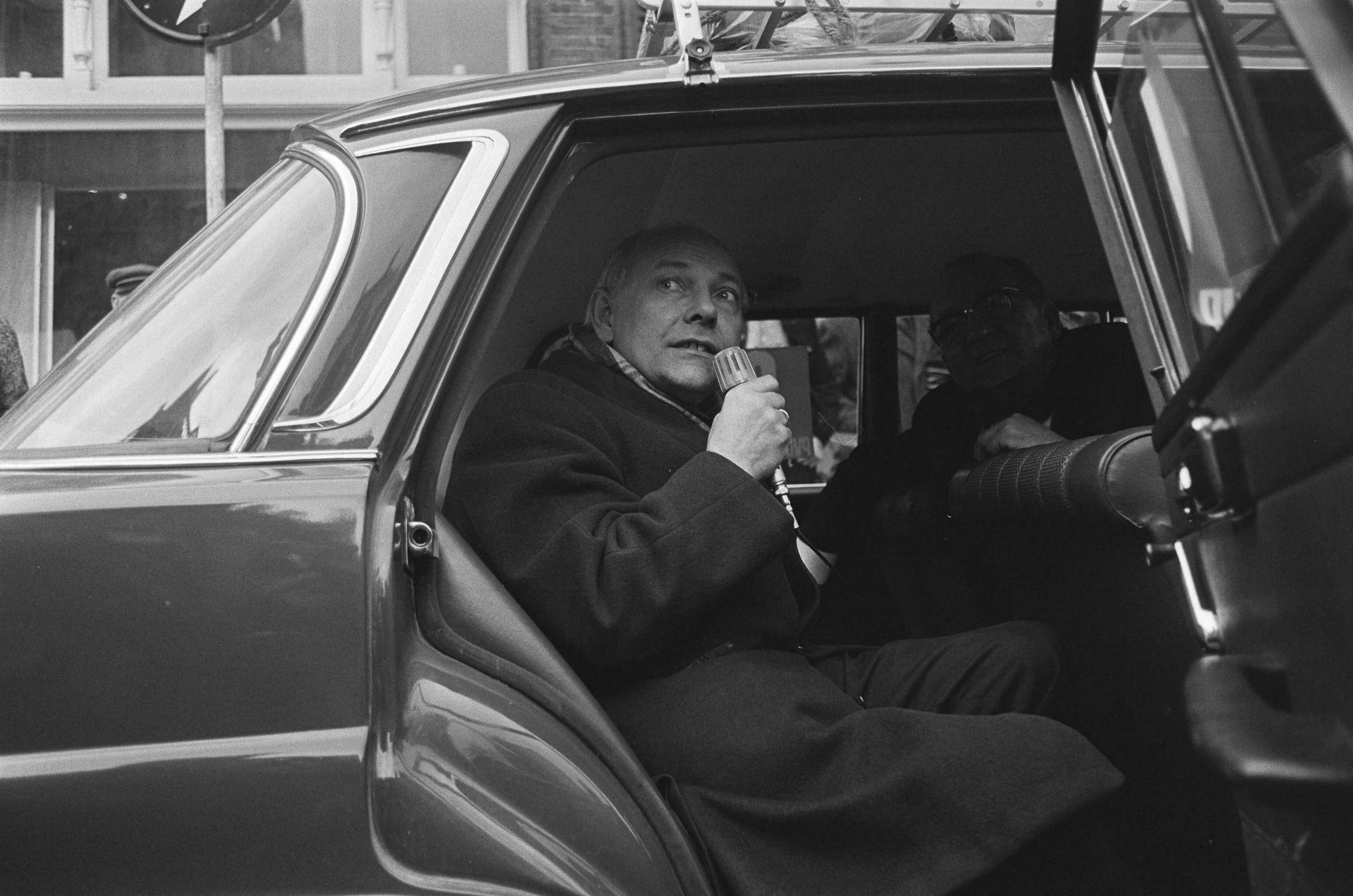 Joop den Uyl in Breda met een karavaan op verkiezingstournee voor de PvdA — Den Uyl spreekt vanuit de auto — Foto: Fotograaf Onbekend / Anefo. Licentie: Set B: Rechtenvrij / Publiek Domein. Bron: Nationaal Archief. http://hdl.handle.net/10648/abb8e6ca-d0b4-102d-bcf8-003048976d84