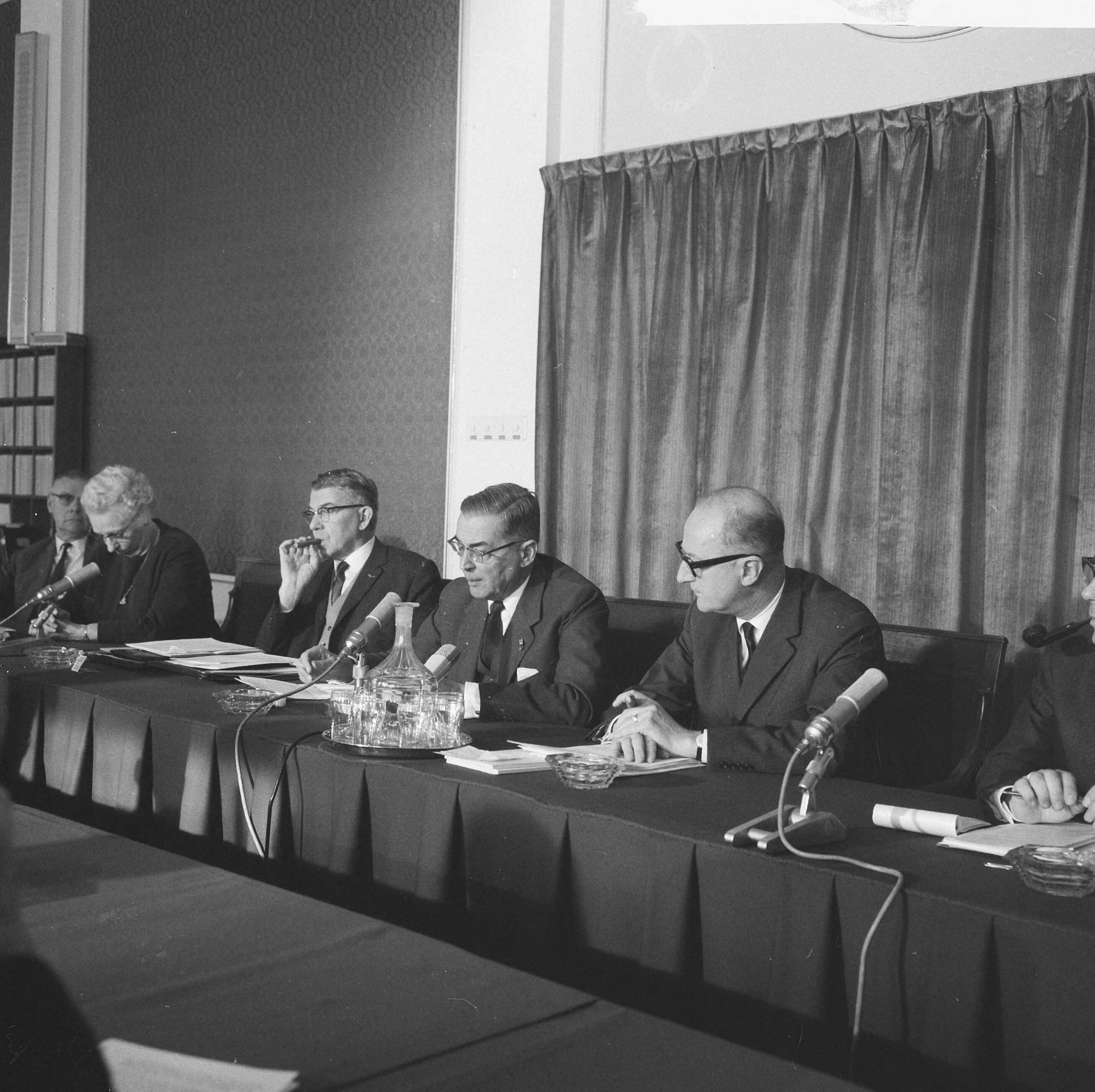 Persconferentie van de colleges van Burgemeester en Wethouders van Den Haag, Amsterdam en Rotterdam in de Raadzaal te Den Haag — Persconferentiie, vlnr. wethouder mevr. Zeelenberg (Rotterdam) , burgemeester Thomassen (Rotterdam), burgemeeste rVan Hall (Amsterdam), loco-burgemeester Schouten (Den Haag) — Foto: Evers, Joost / Anefo. Licentie: Set B: Rechtenvrij / Publiek Domein. Bron: Nationaal Archief. http://hdl.handle.net/10648/aac9ca72-d0b4-102d-bcf8-003048976d84