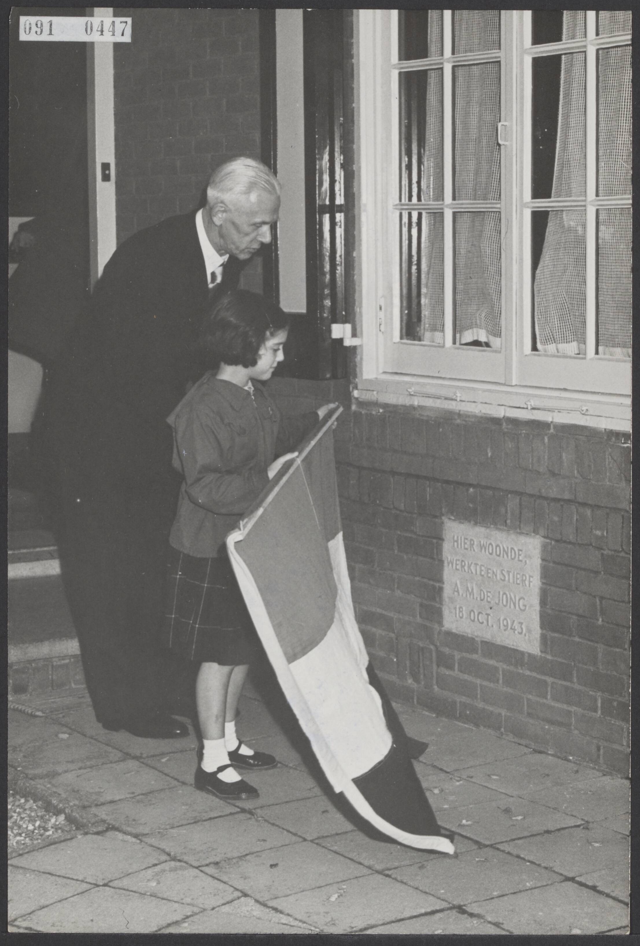 Fotocollectie Elsevier Binnenland — Herdenking van de schrijver A.M. de Jong die op 17 oktober 1943 door de z.g. Silbertanne-moord in zijn woning te Blaricum werd vermoord. In de gevel van zijn ouderlijk huis is een steen onthuld door een van zijn kleinkinderen, bijgestaan door de oud-burgemeester van Blarium en voorzitter van het Herdenkingscomité, J.J. Klaarenbeek — Foto: Fotograaf Onbekend / Anefo. Licentie: Set B: Rechtenvrij / Publiek Domein. Bron: Nationaal Archief. http://hdl.handle.net/10648/ae200380-d0b4-102d-bcf8-003048976d84