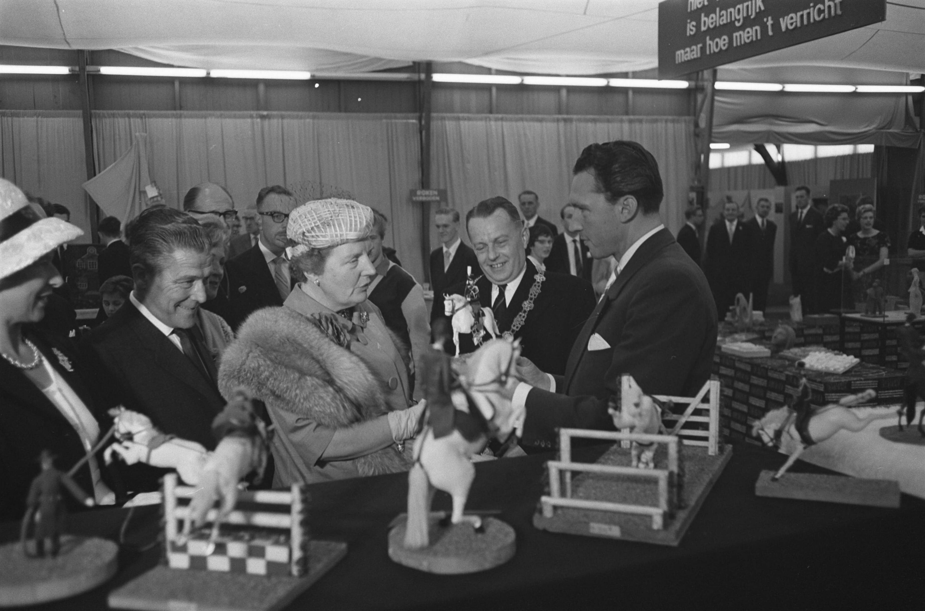 Fotocollectie Anefo — Koningin Juliana bezoekt tentoonstelling "Nu .... Breda 61 ". In de hobbyhal bood de heer H. van der Kroon haar een door hem zeil vervaardigd paardje met ruiter van leer aan, bestemd voor prinses Marijke — Foto: Pot, Harry / Anefo. Licentie: Set B: Rechtenvrij / Publiek Domein. Bron: Nationaal Archief. http://hdl.handle.net/10648/a9dd1b8c-d0b4-102d-bcf8-003048976d84