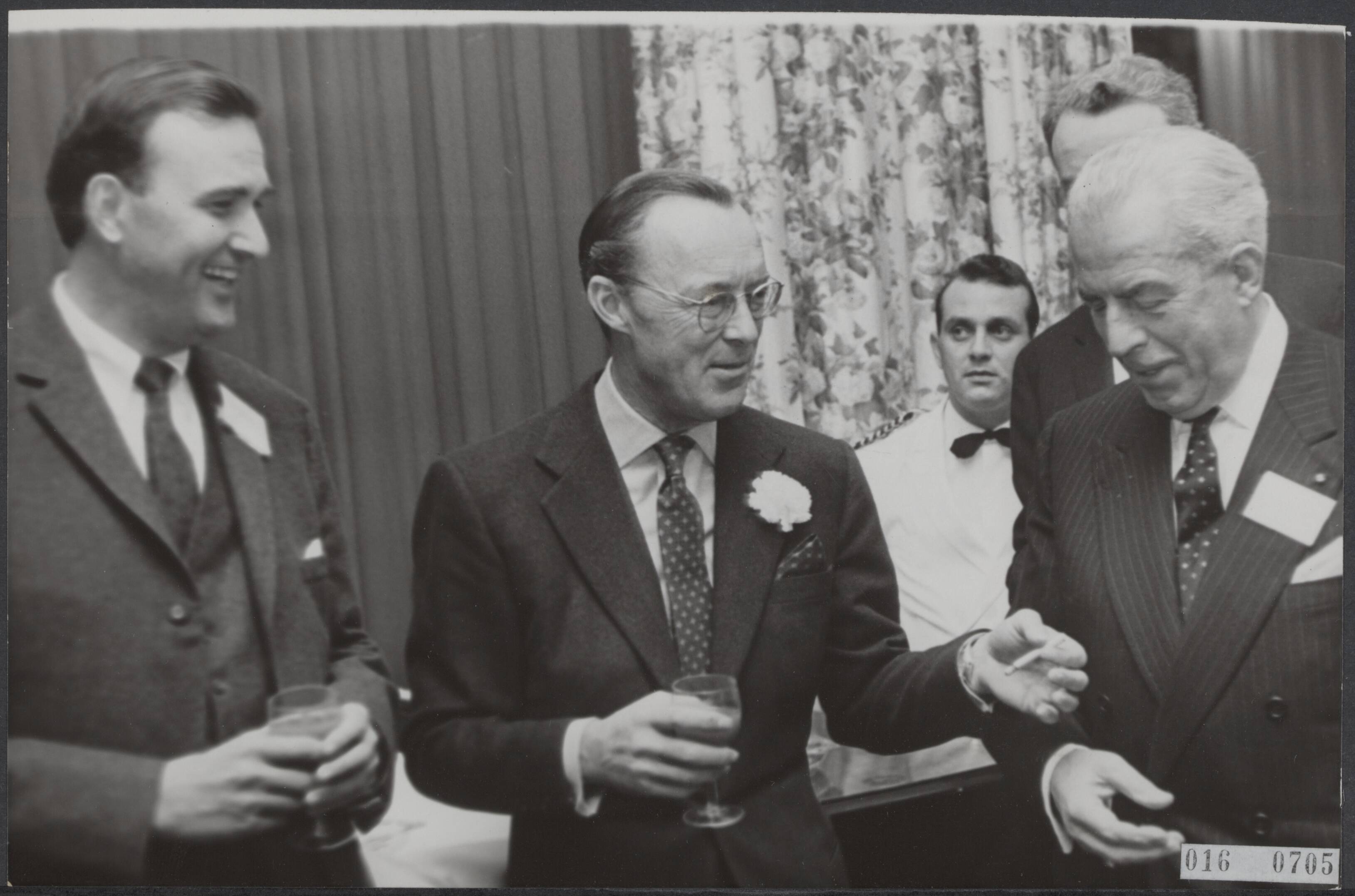 Fotocollectie Elsevier Binnenland — Prins Bernhard heeft in het Kurhaus te Scheveningen als eregast aangezeten aan de lunch van de American Association, een vereniging van Amerikaanse zakenmensen in Nederland. De prins in gesprek met de voorzitter van de vereniging David C. Tausche, bankdirecteur (links), en de andere eregast, jhr. H.A. van Karnebeek, voorzitter van het Nederlands Olympisch Comité — Foto: Koch, Eric / Anefo. Licentie: Set B: Rechtenvrij / Publiek Domein. Bron: Nationaal Archief. http://hdl.handle.net/10648/adba2f56-d0b4-102d-bcf8-003048976d84