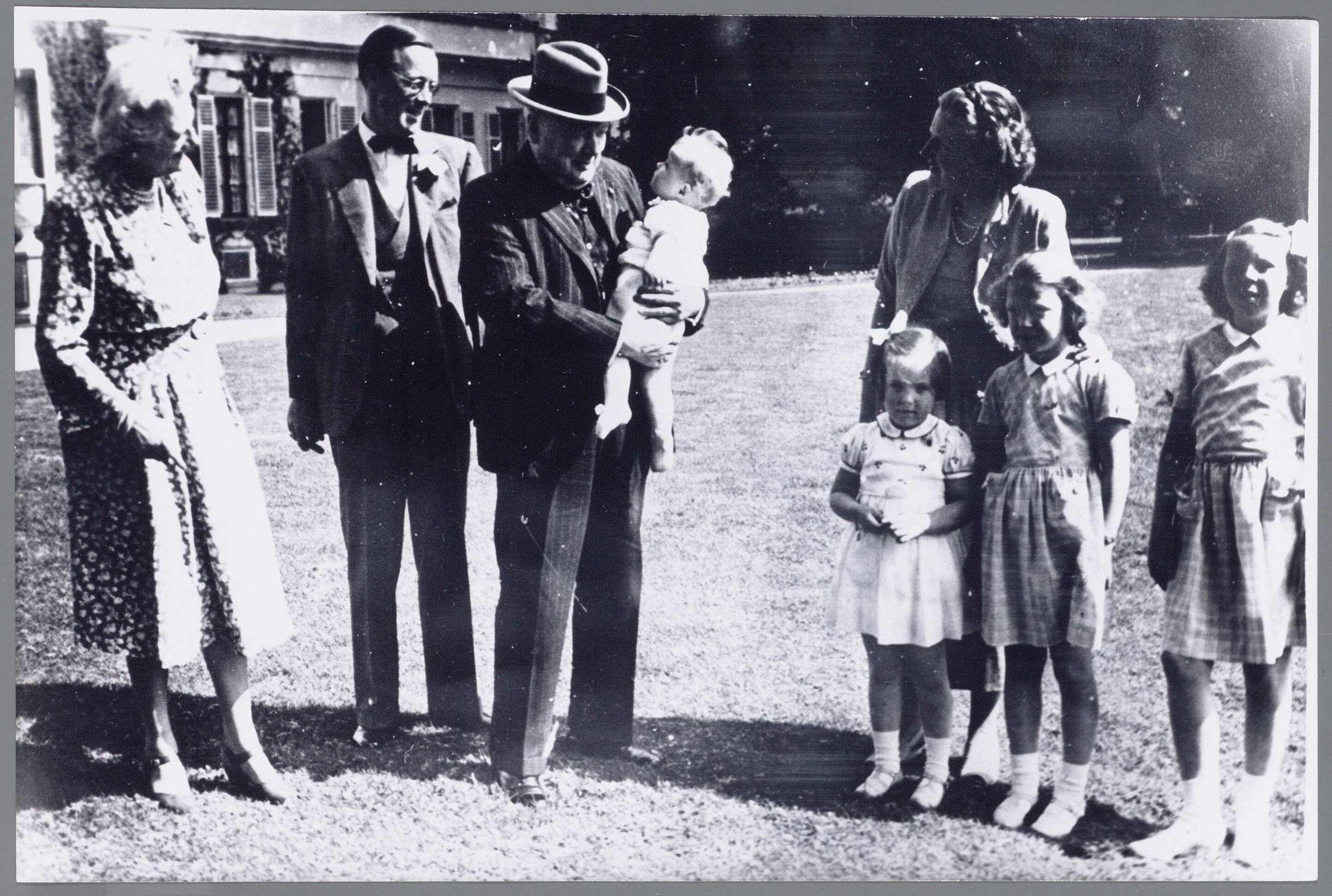 Fotocollectie RVD / Koninklijk Huis — Winston Churchill en mw. Churchill met prinses Juliana en prins Bernhard en de prinsessen Beatrix, Irene, MArgriet en Marijke op 8 mei 1948 in de tuin van Paleis Soestdijk — Foto: Fotograaf Onbekend / Anefo. Licentie: Set B: Rechtenvrij / Publiek Domein. Bron: Nationaal Archief. http://hdl.handle.net/10648/afac6b94-d0b4-102d-bcf8-003048976d84