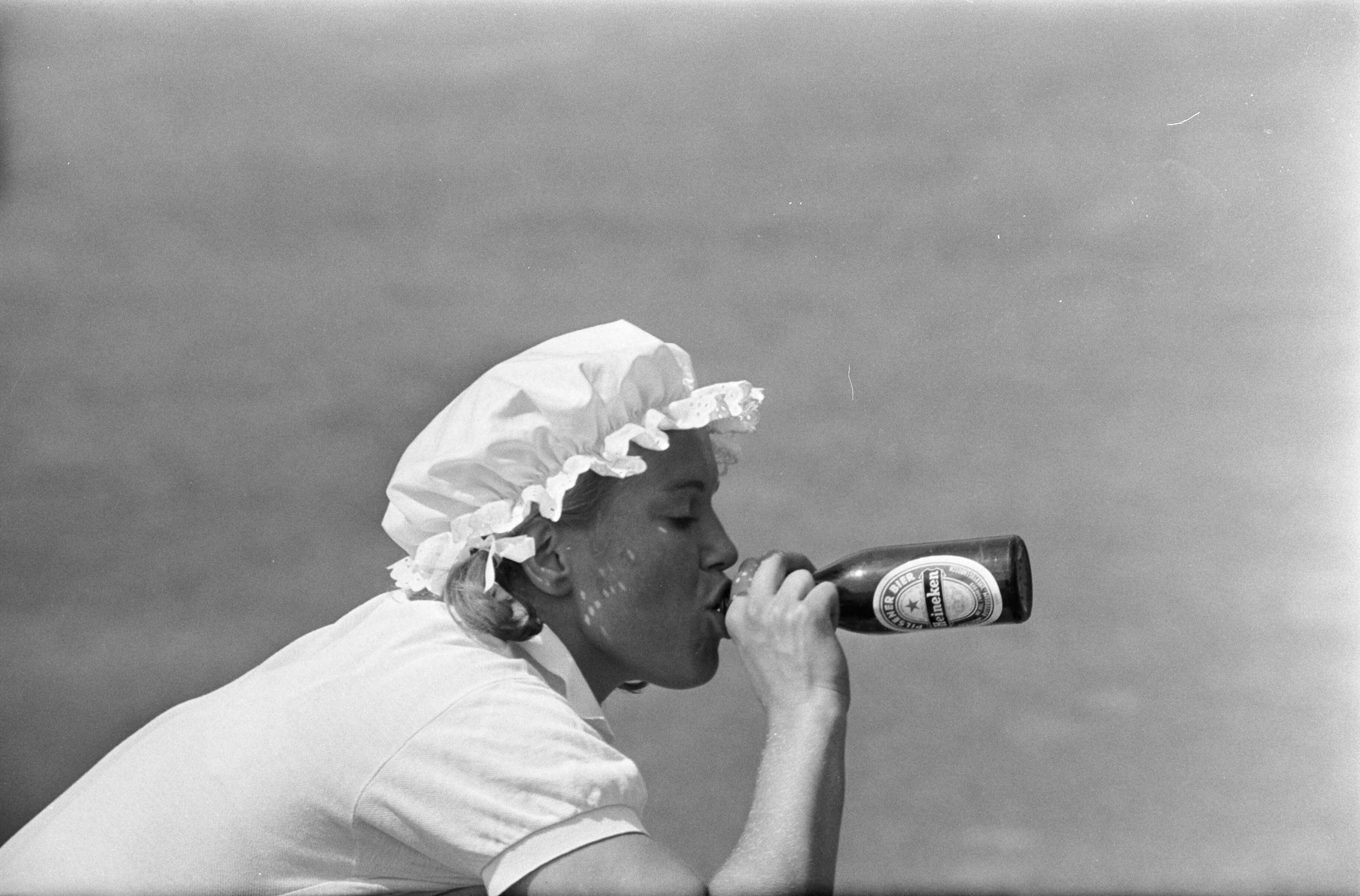 Fotocollectie Anefo — Nationale tenniskampioenschappen op Mets-banen te Scheveningen: Ellen Sluiter drinkt bier — Foto: Koch, Eric / Anefo. Licentie: Set B: Rechtenvrij / Publiek Domein. Bron: Nationaal Archief. http://hdl.handle.net/10648/ab75c55c-d0b4-102d-bcf8-003048976d84