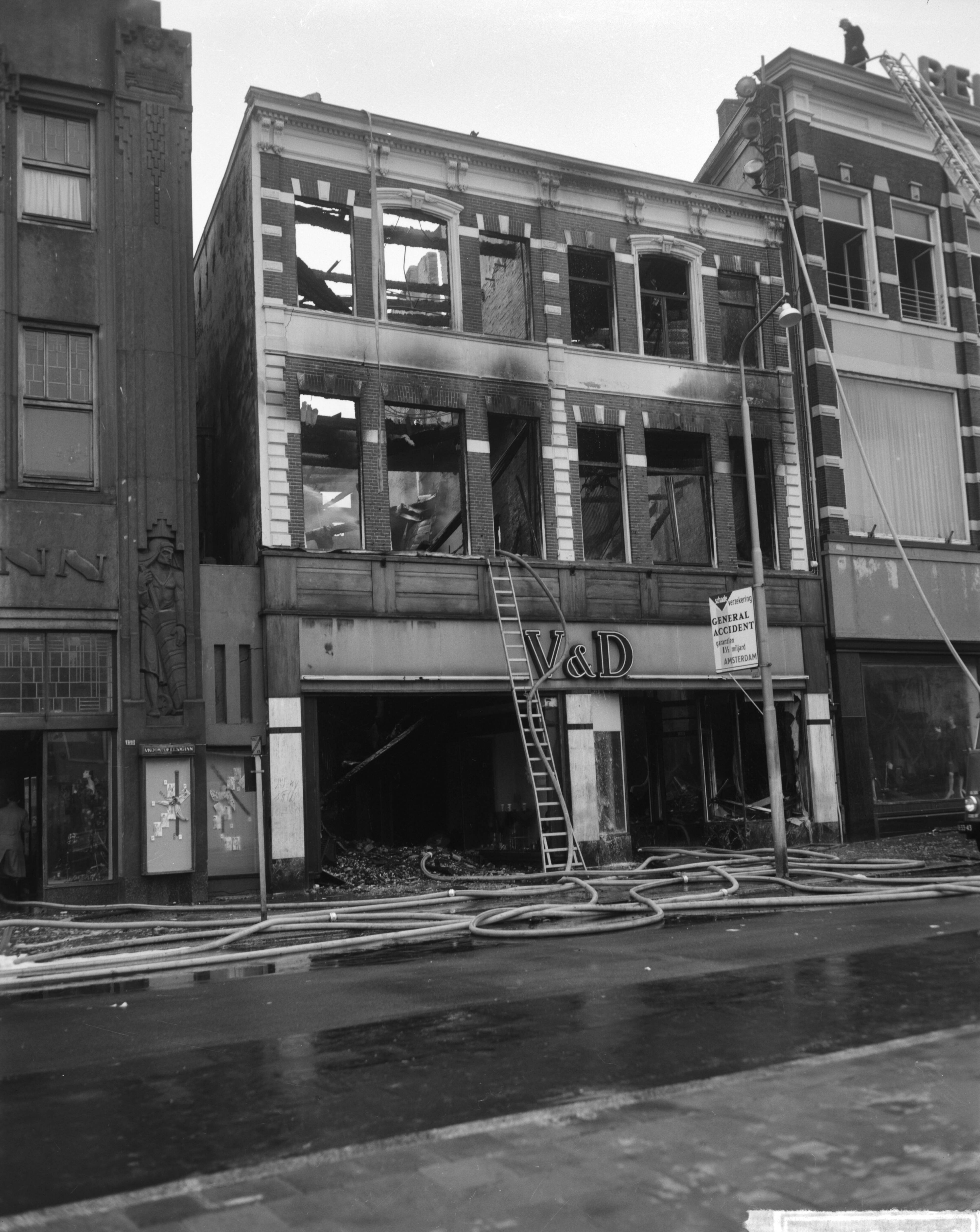 Fotocollectie Anefo — Brand bij V&D te Leeuwarden. Onbeschadigde confectie wordt in veiligheid gebracht — Foto: Bilsen, Joop van / Anefo. Licentie: Set B: Rechtenvrij / Publiek Domein. Bron: Nationaal Archief. http://hdl.handle.net/10648/aa2ed8be-d0b4-102d-bcf8-003048976d84