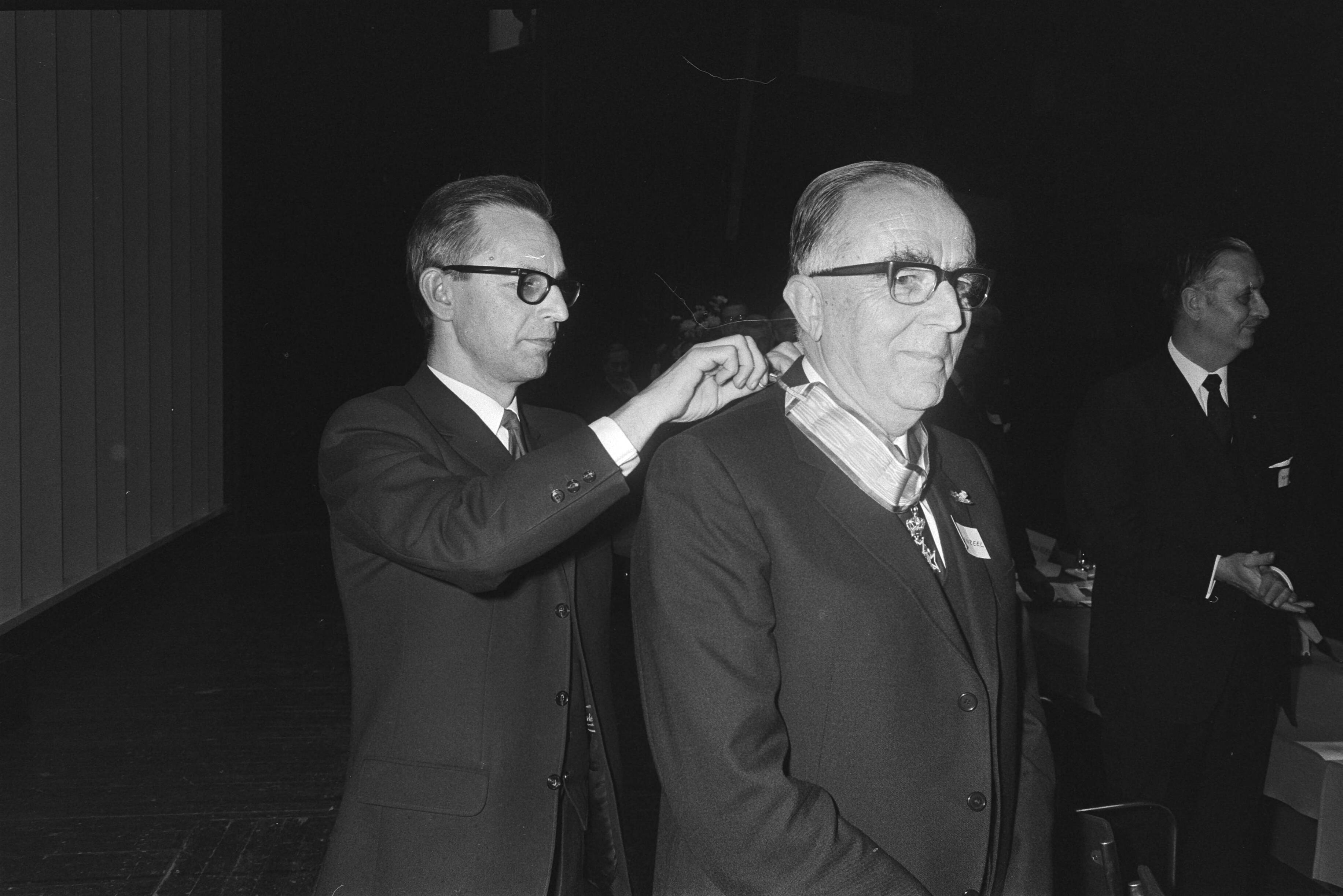 Fotocollectie Anefo — Alg. Verg. Verbond Ned. Ondern. Den Haag, Congresgeb.; Nelissen hangt W. Bruynzeel versierselen omCommandeurschap Oranje — Foto: Koch, Eric / Anefo. Licentie: Set B: Rechtenvrij / Publiek Domein. Bron: Nationaal Archief. http://hdl.handle.net/10648/abaa4b56-d0b4-102d-bcf8-003048976d84