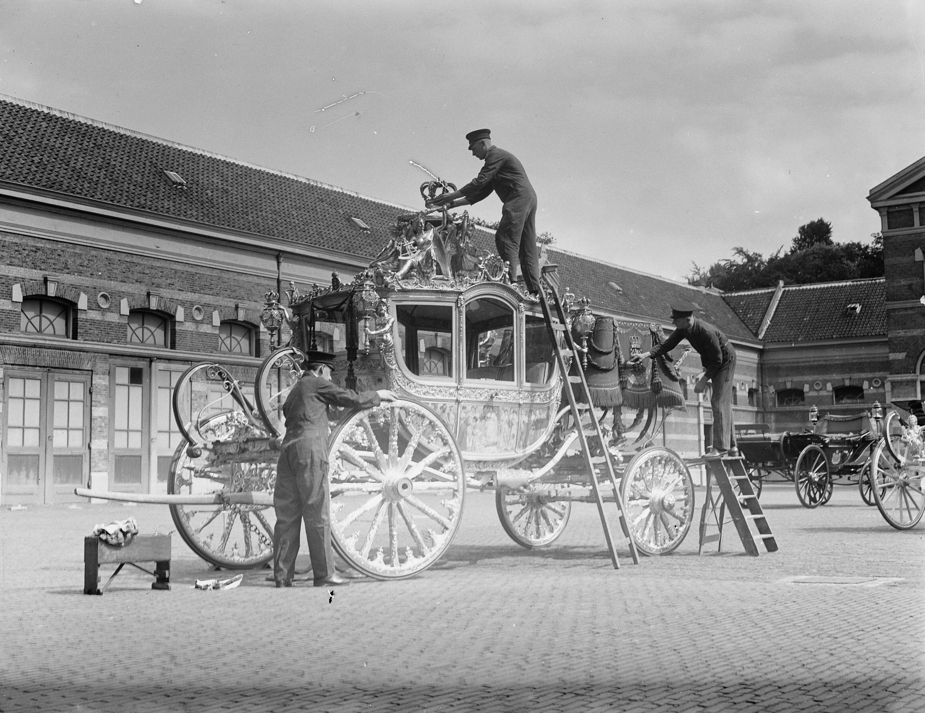 Koninklijke Stallen te Den Haag. Voorbereidingen viering Regeringsjubileum — Koninklijks Stallen te Den Haag. Gouden Koets wordt schoongemaakt — Foto: Merk, Ben / Anefo. Licentie: Set B: Rechtenvrij / Publiek Domein. Bron: Nationaal Archief. http://hdl.handle.net/10648/a8babb60-d0b4-102d-bcf8-003048976d84
