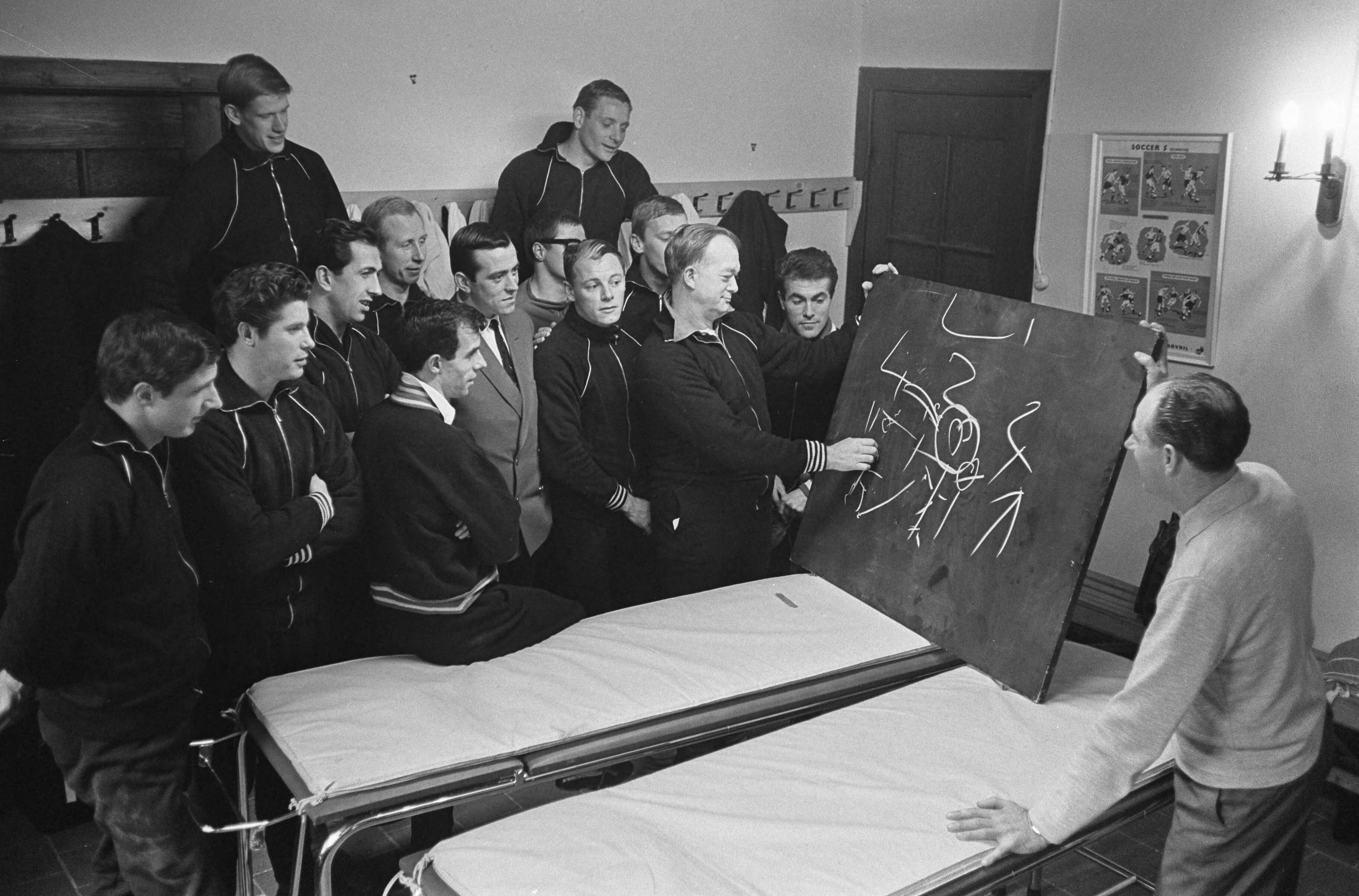 Fotocollectie Anefo — Training Nederlands elftal, Denis Neville geeft enkele theoretische wenken aan spelers — Foto: Koch, Eric / Anefo. Licentie: Set B: Rechtenvrij / Publiek Domein. Bron: Nationaal Archief. http://hdl.handle.net/10648/aa934ad8-d0b4-102d-bcf8-003048976d84