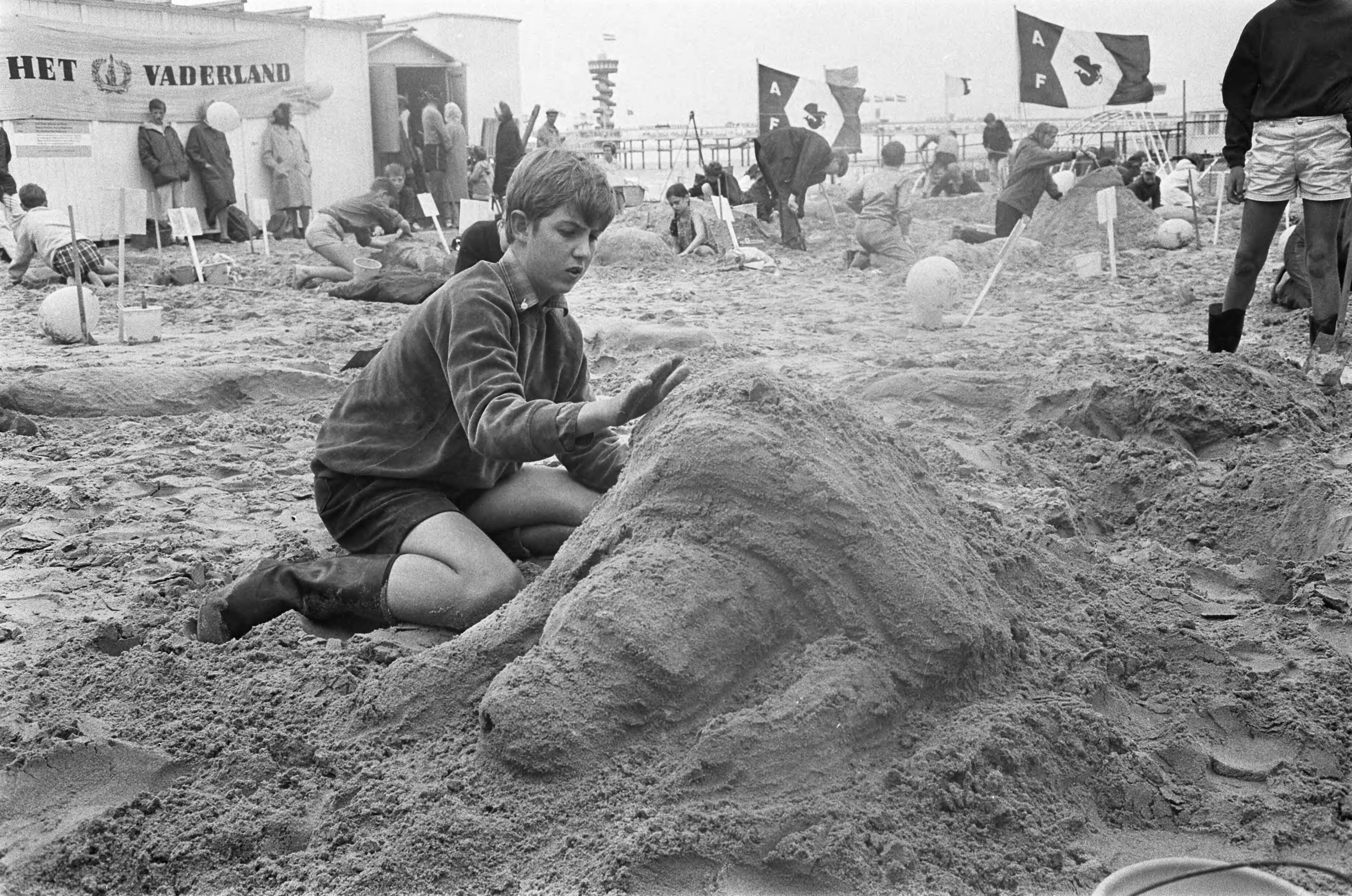 Finale Zandbouwwedstrijd op strand Scheveningen — Deelnemer aan het werk — Foto: Fotograaf Onbekend / Anefo. Licentie: Set B: Rechtenvrij / Publiek Domein. Bron: Nationaal Archief. http://hdl.handle.net/10648/ab1f1b8a-d0b4-102d-bcf8-003048976d84